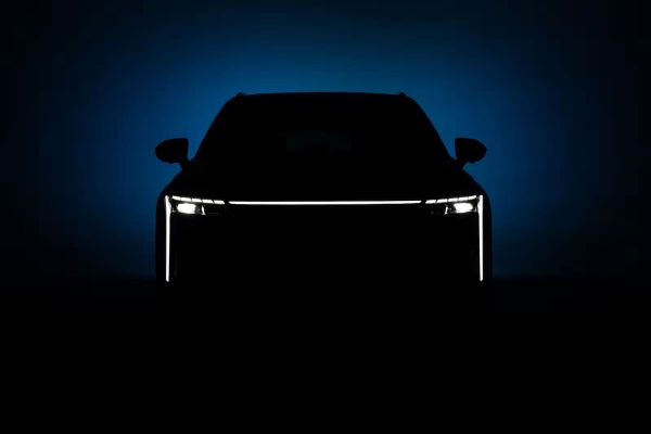 Silhouette of an OMODA 9 Black Noble teaser with a glowing front light bar