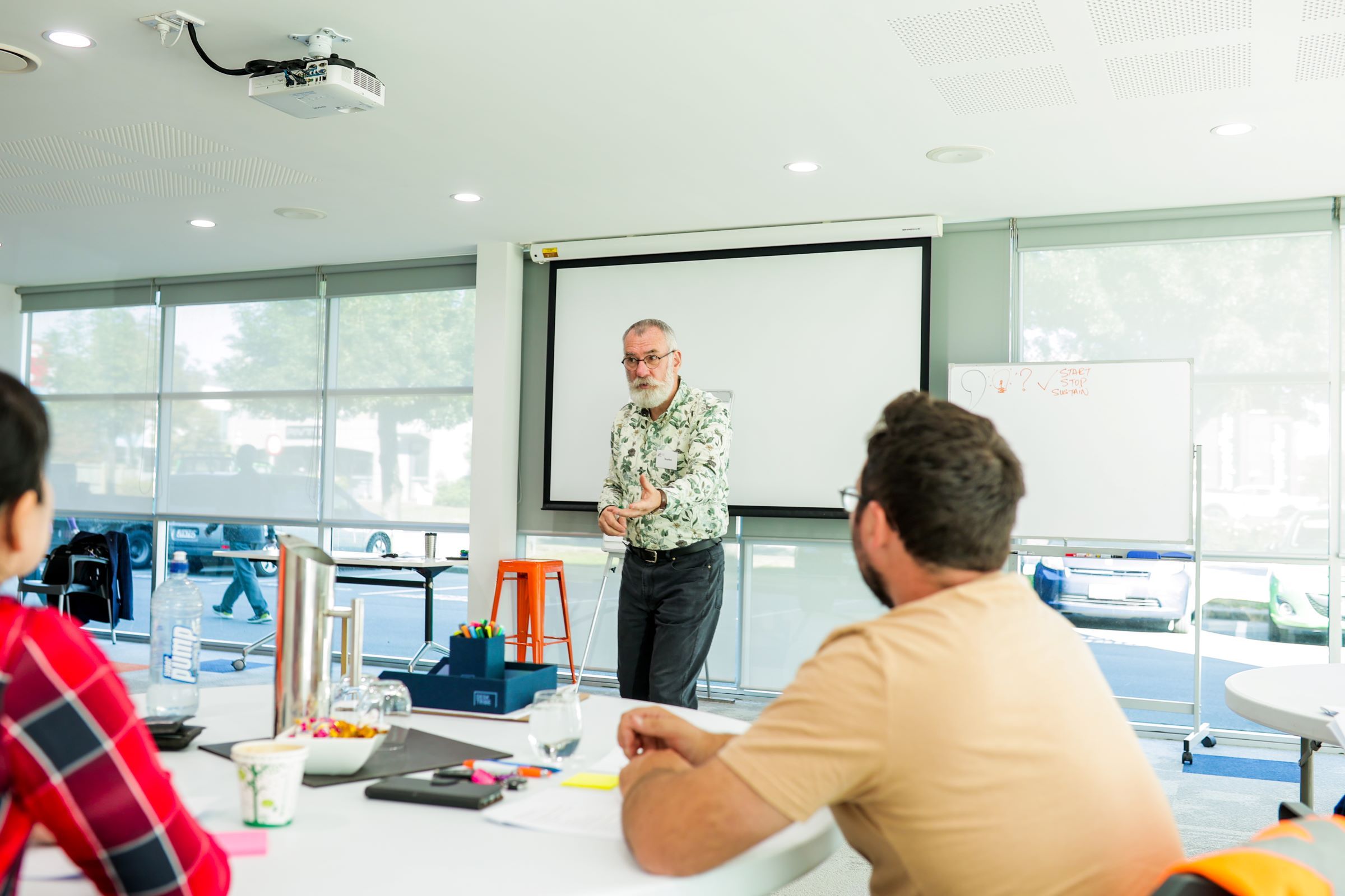 Male facilitator reaching out to class participants as he makes a point