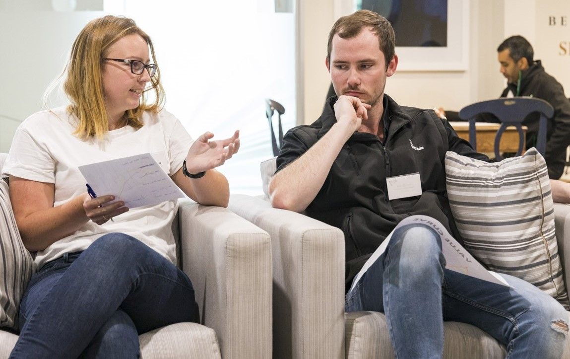 A man and woman, both seated, discussing leadership