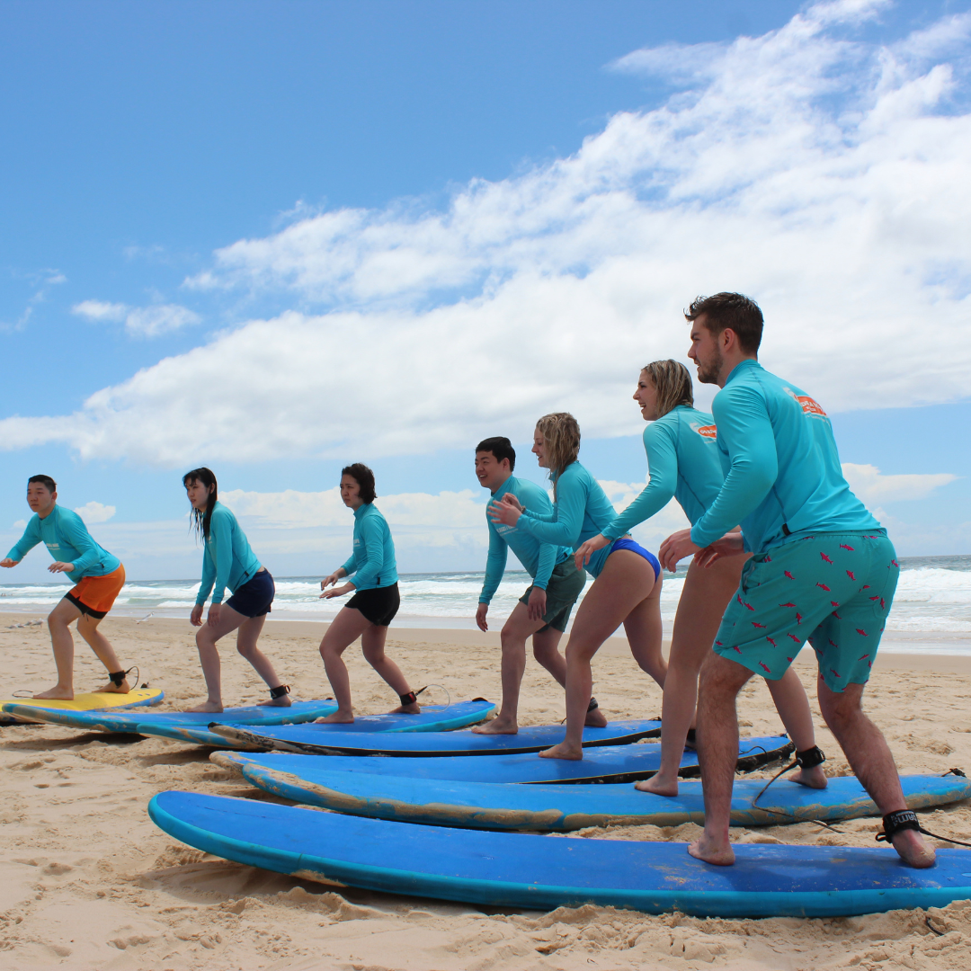 Surf students getting instructions on their surfboards on the beach