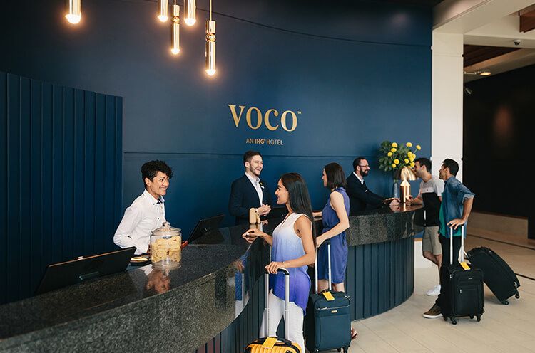 A Group Of People Standing In A Room