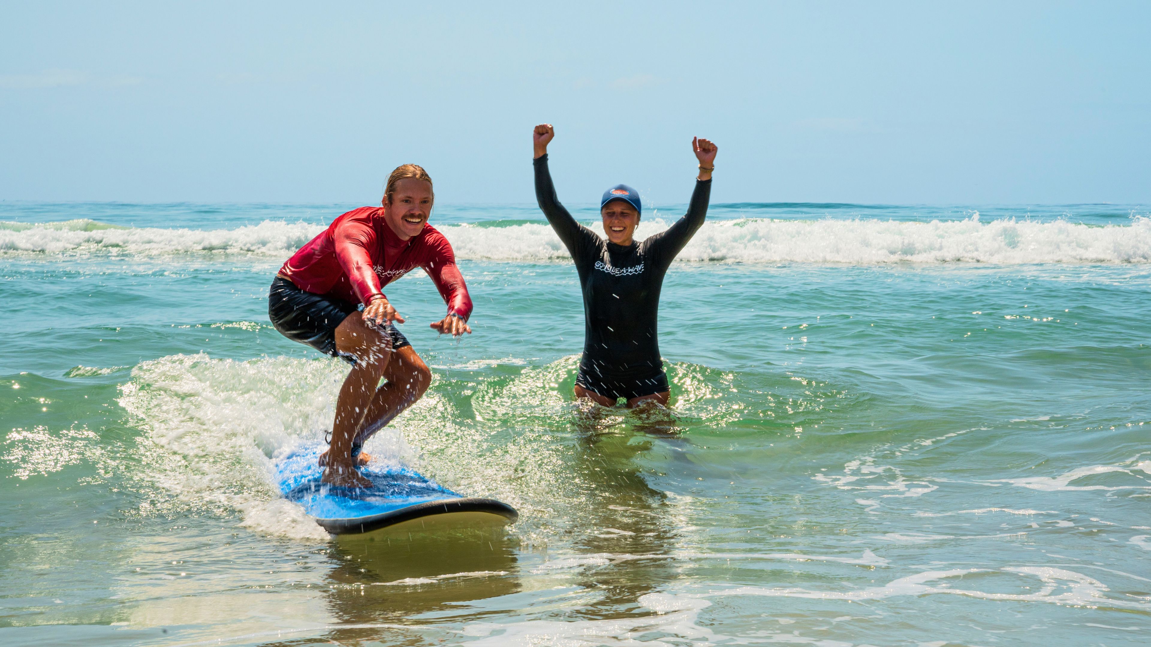 Beginner surf lesson on the Gold Coast with Go Ride A Wave instructor cheering as student rides a wave.