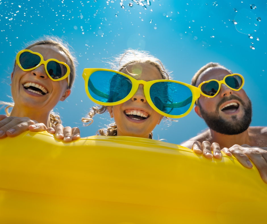 family having fun on beach wearing quirky glasses