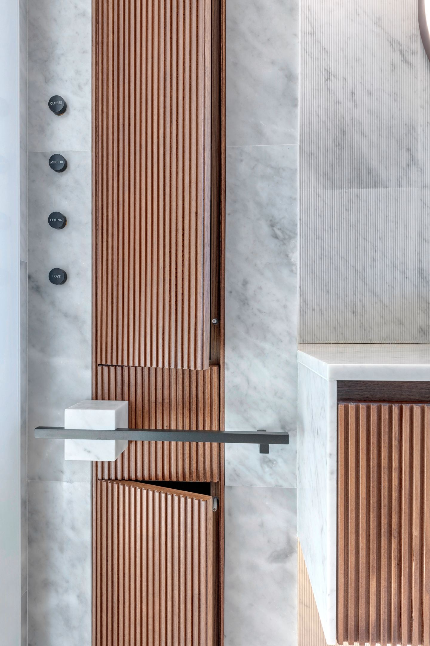 Fluted walnut meeting marble at the bath