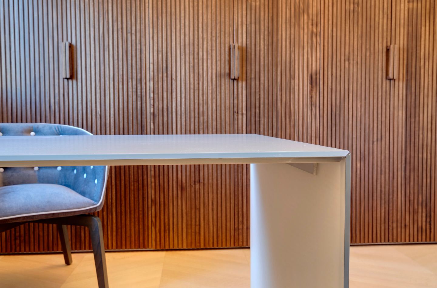 Glass desk against the walnut slat wall