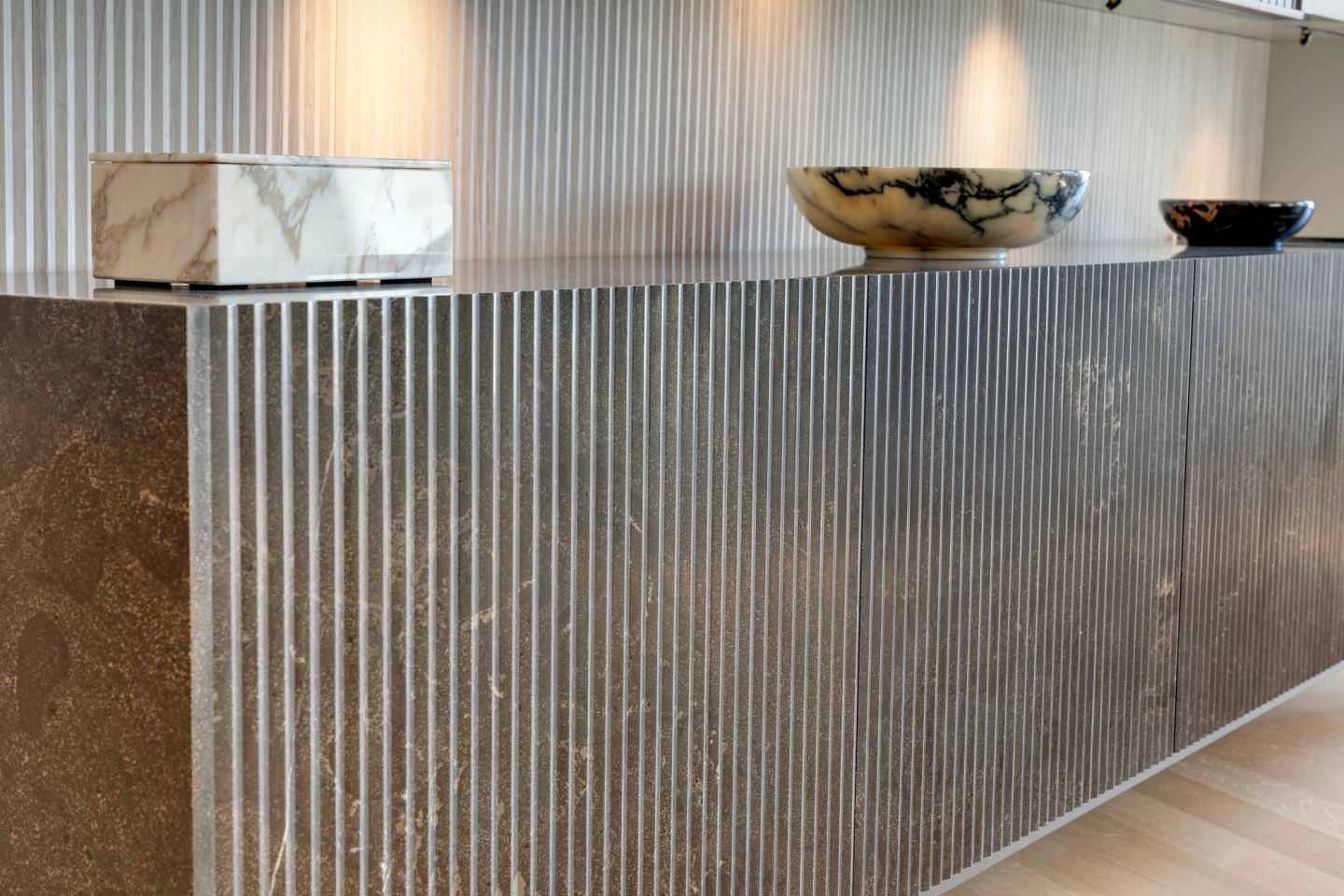 Fluted stone sideboard front with marble objects on top