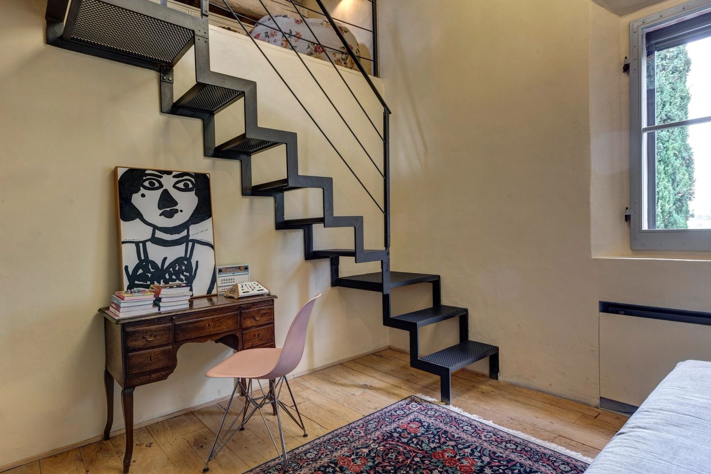The iron stair with its new perforated treads, a desk beneath