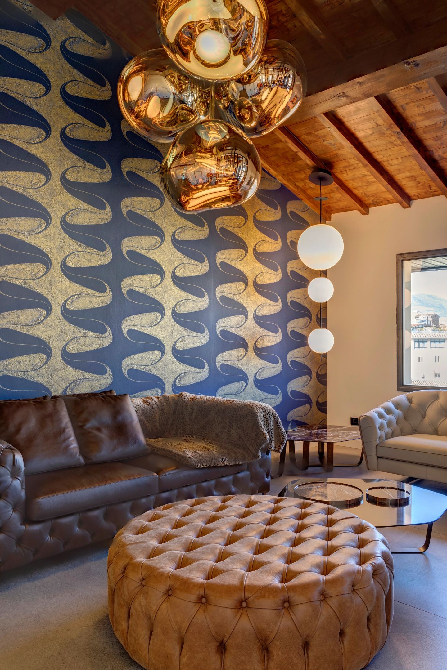 Sofas, ottoman and the copper globes under the roof beams