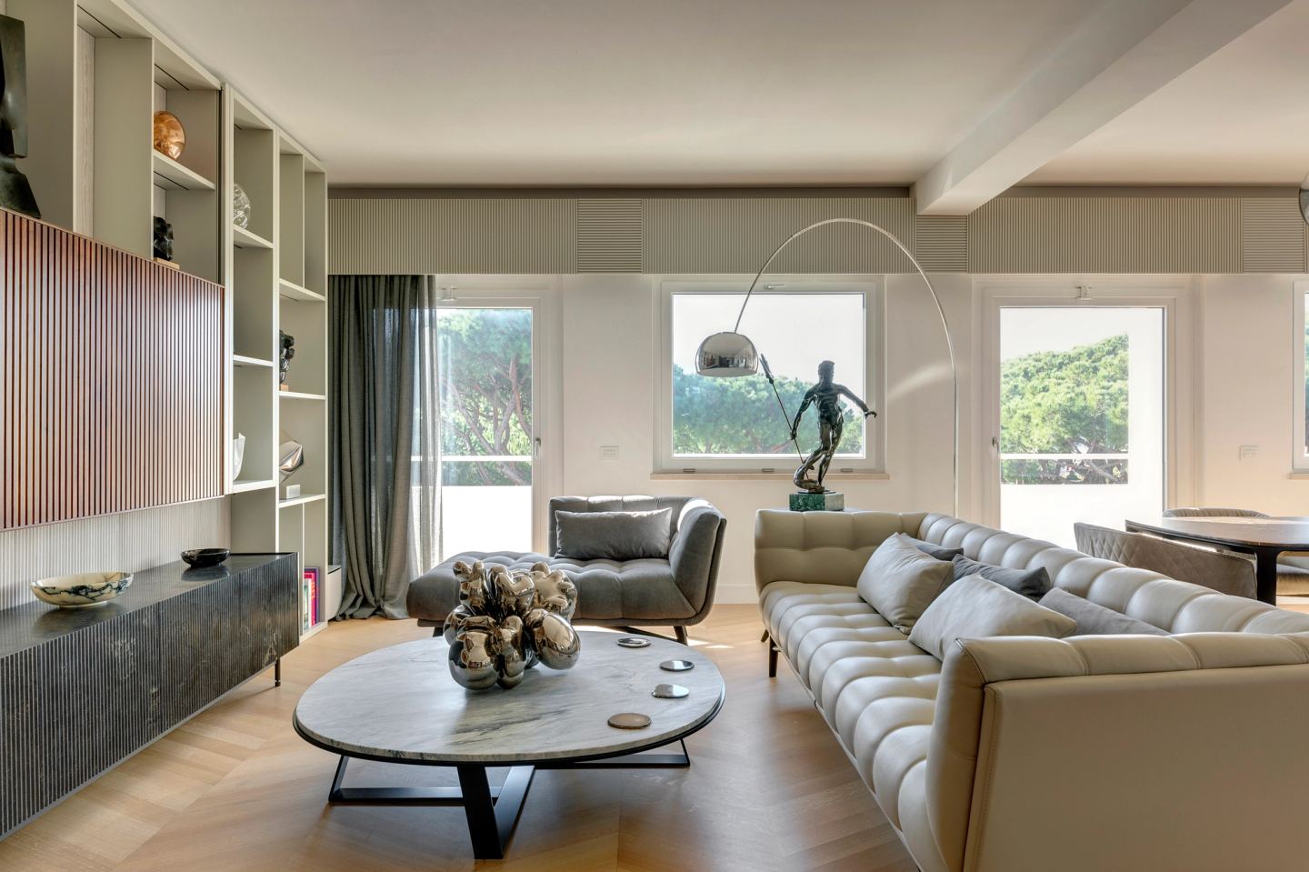 Tufted sofa and oval marble coffee table, with the sea beyond the windows