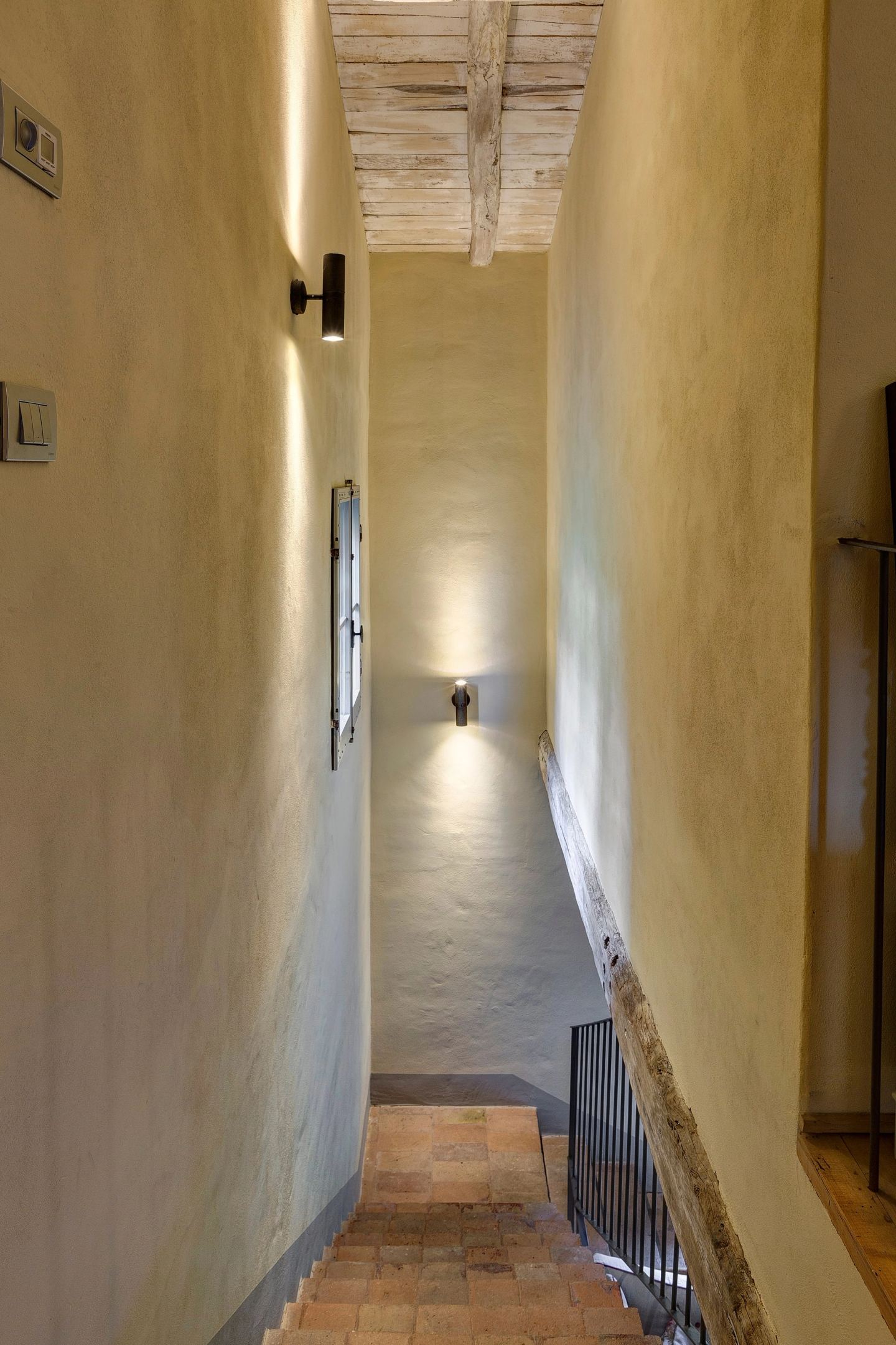 Wall lights casting soft pools along the corridor