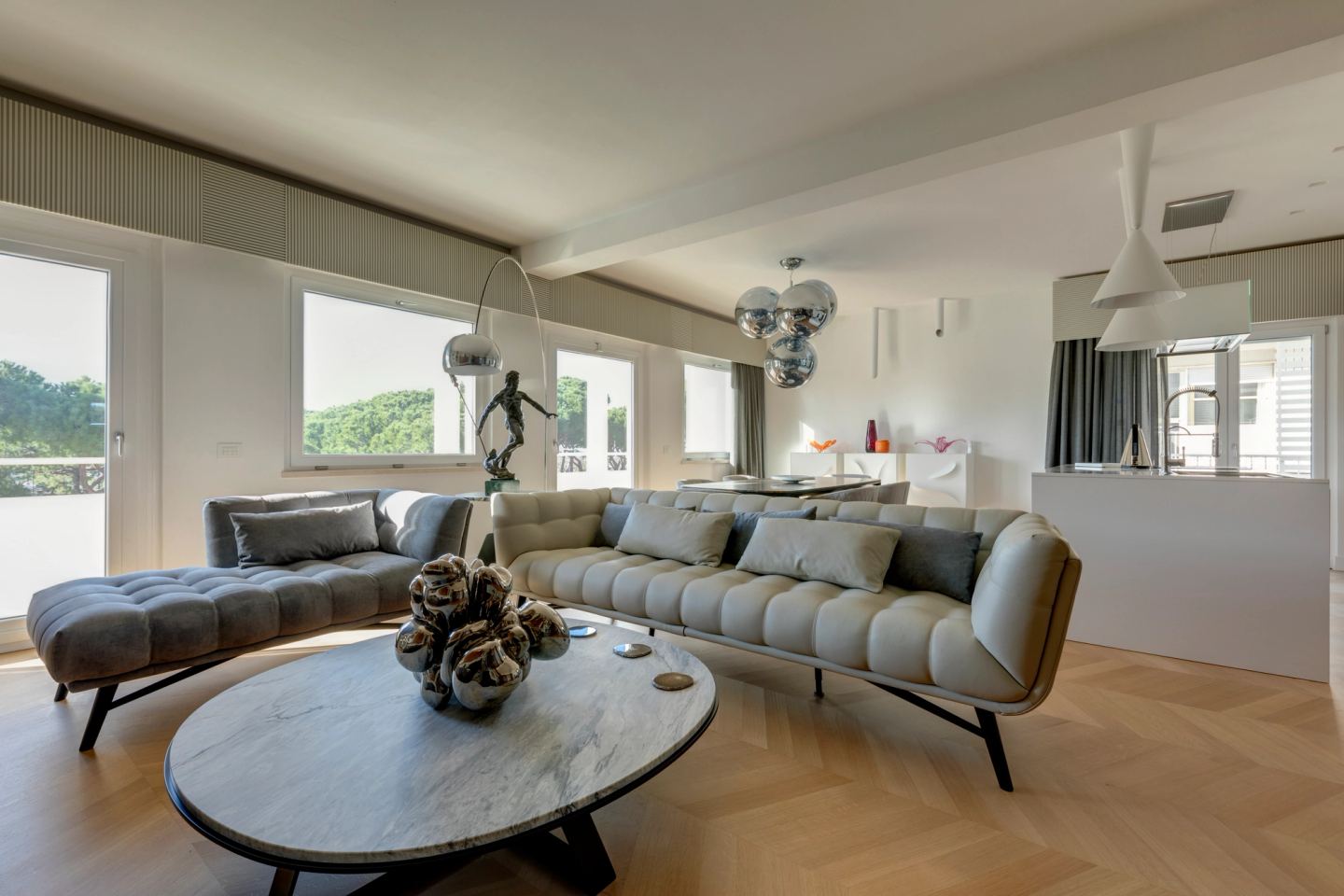 Oval marble coffee table, close, with the tufted sofa behind