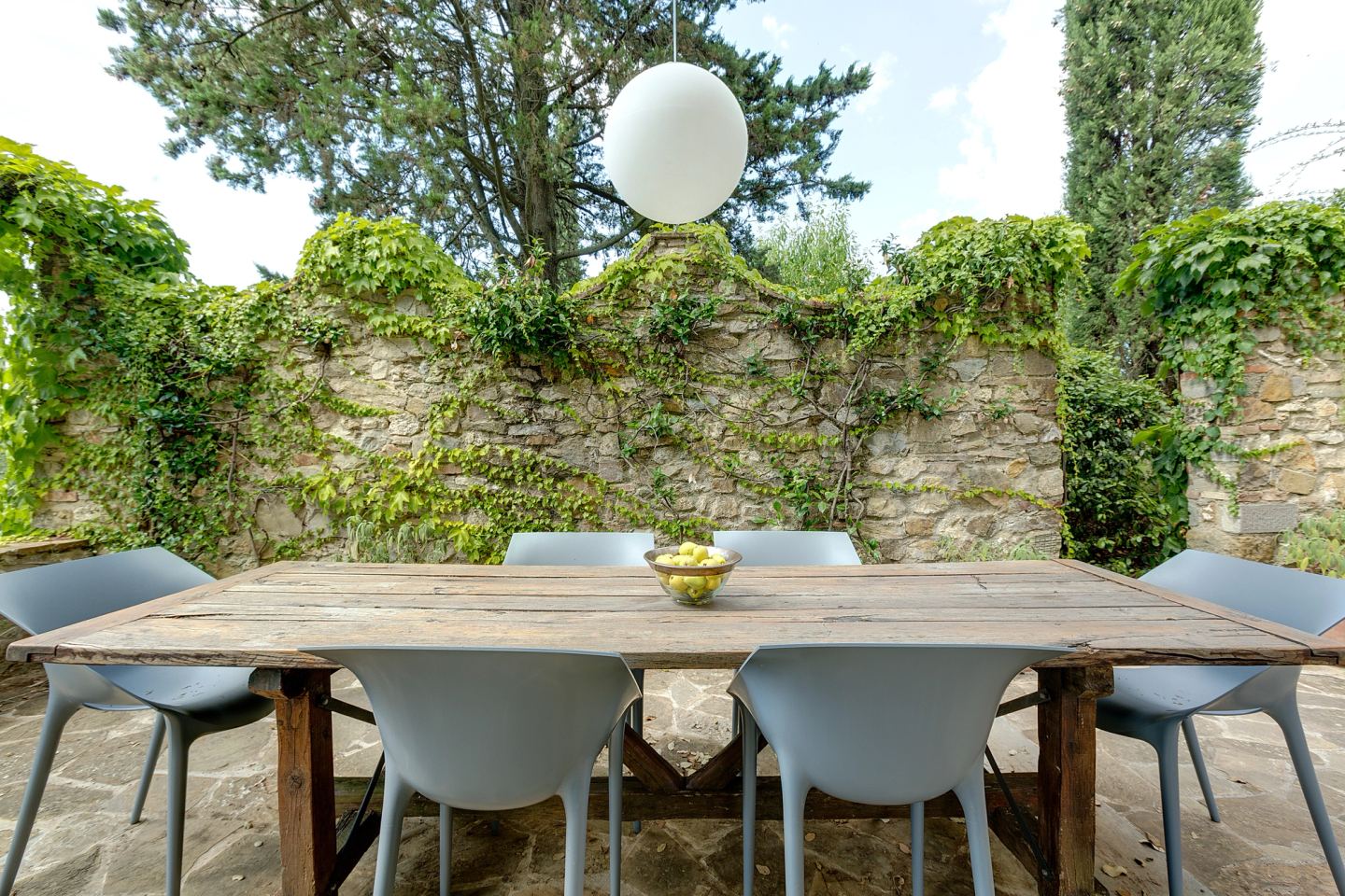 Grey chairs at the timber table by the old wall