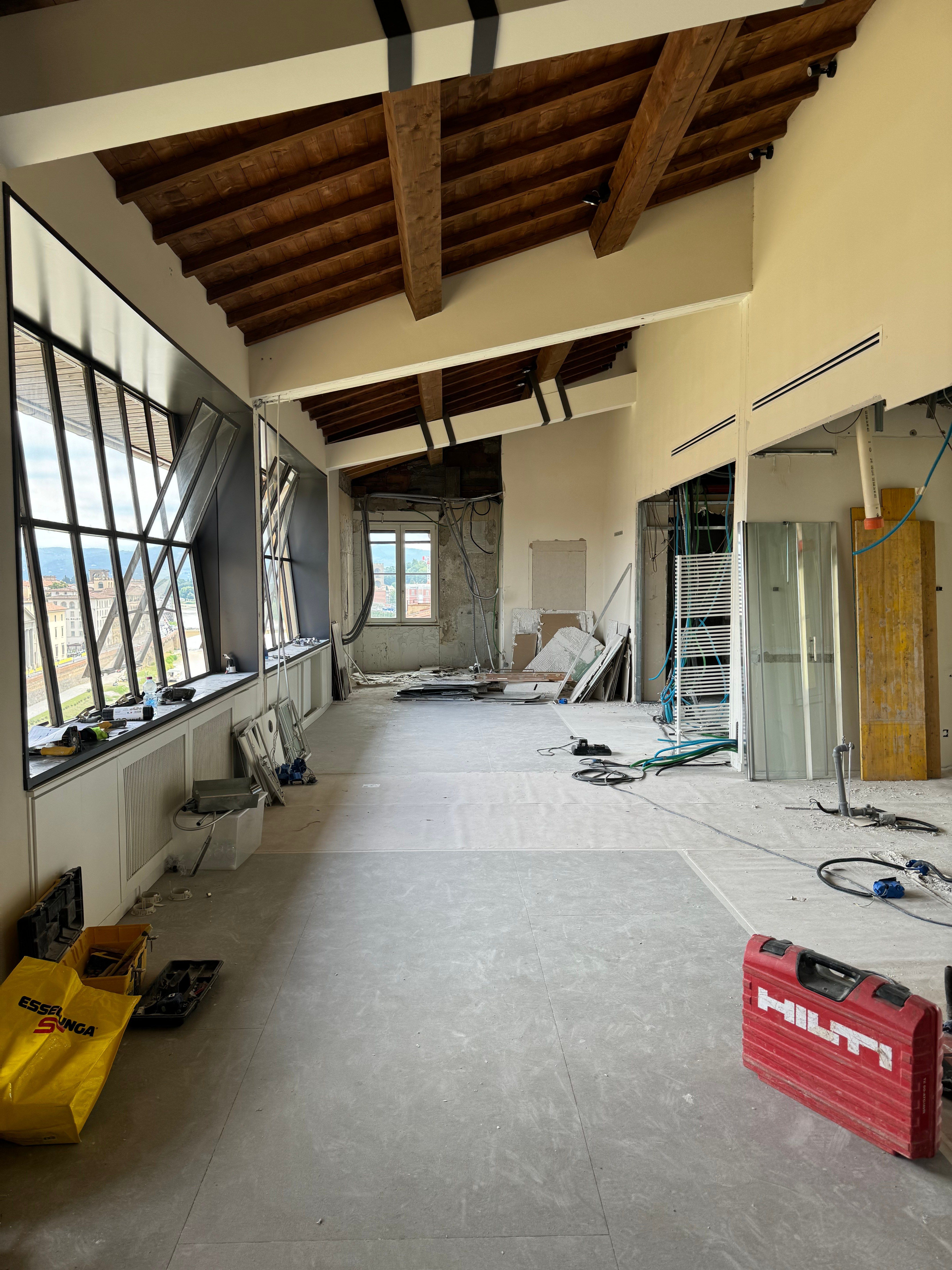 The long room stripped back, the slanting window wall on the left and the roof beams overhead