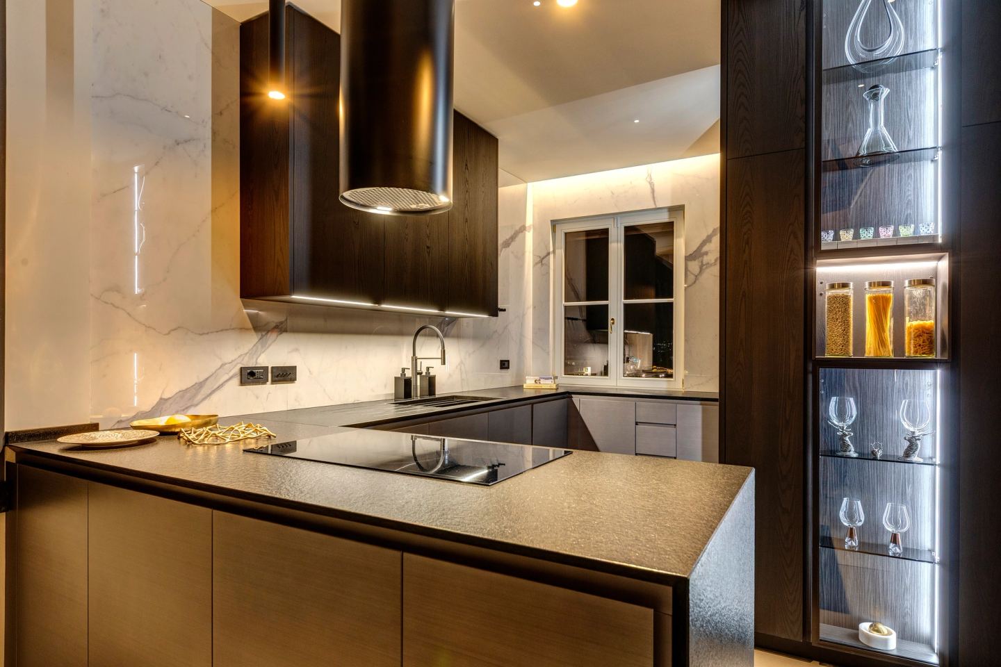 The kitchen at night, the marble splashback catching the light
