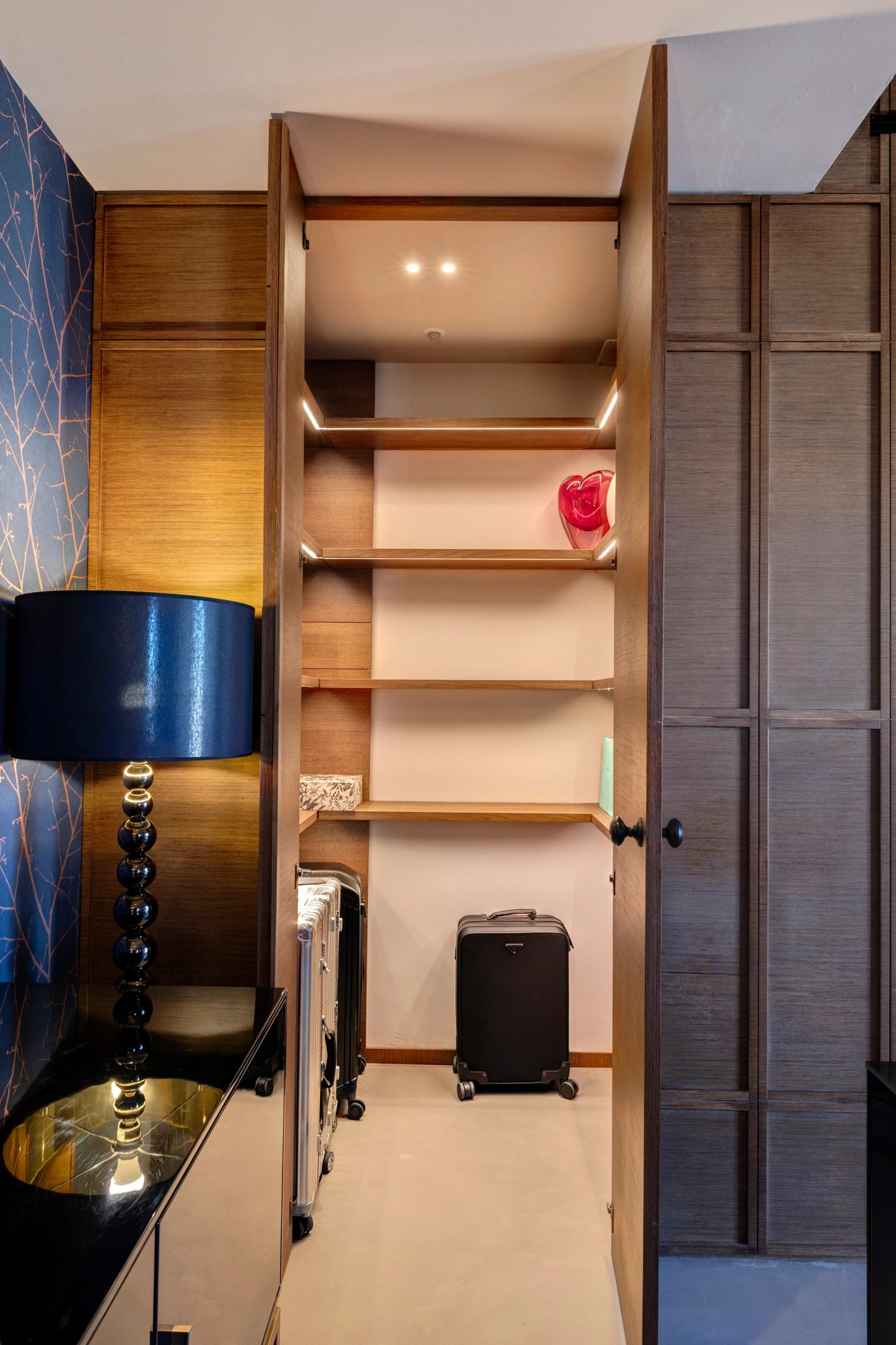 La boiserie si apre, rivelando un armadio walk-in.