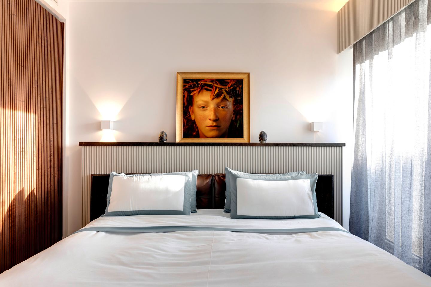 Reading lights either side of the painting above the fluted headboard