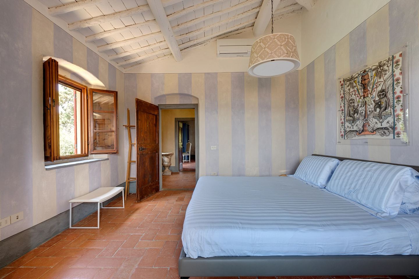 La camera a righe, una stampa sopra il letto