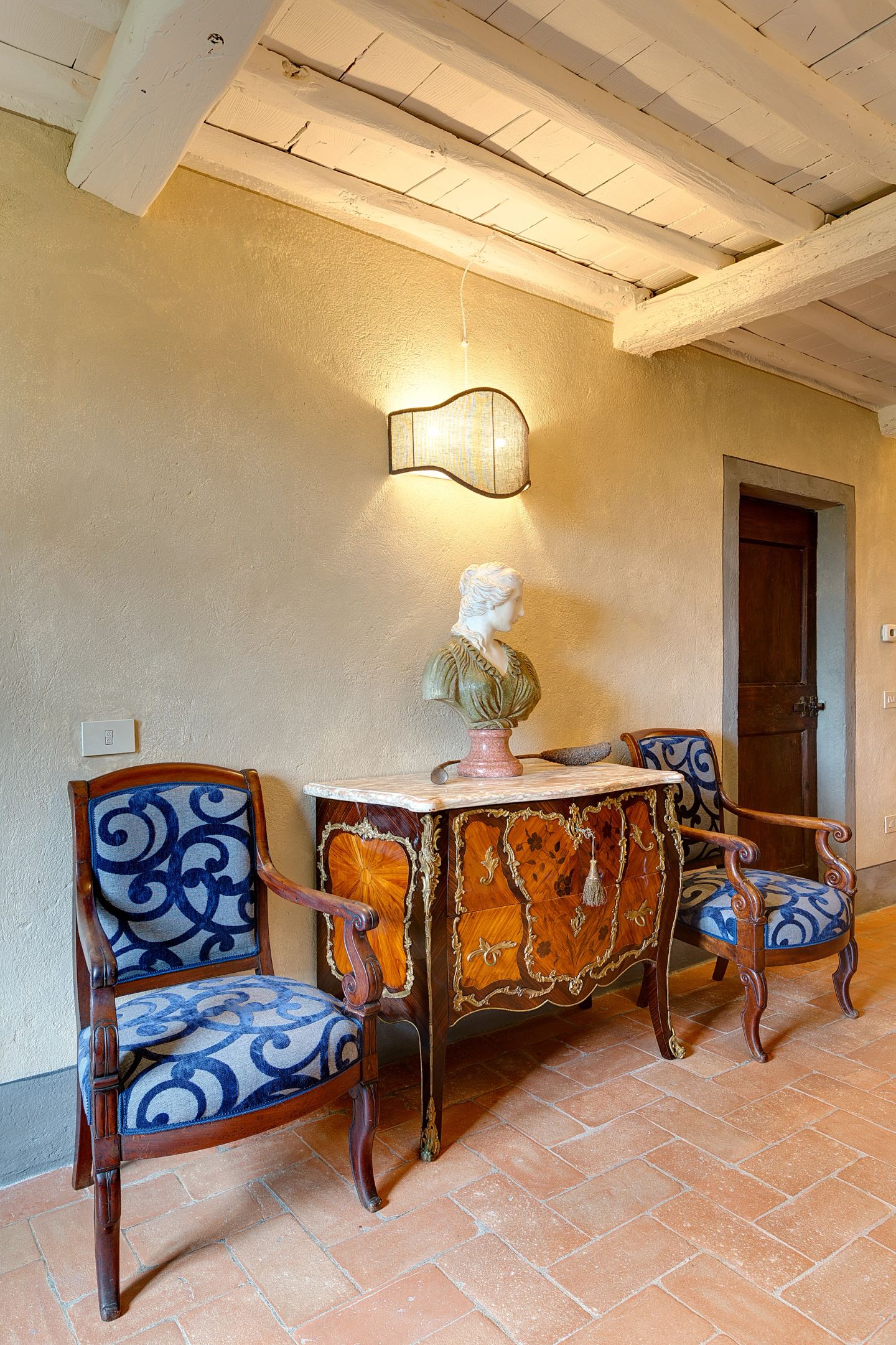 The painted commode between two chairs