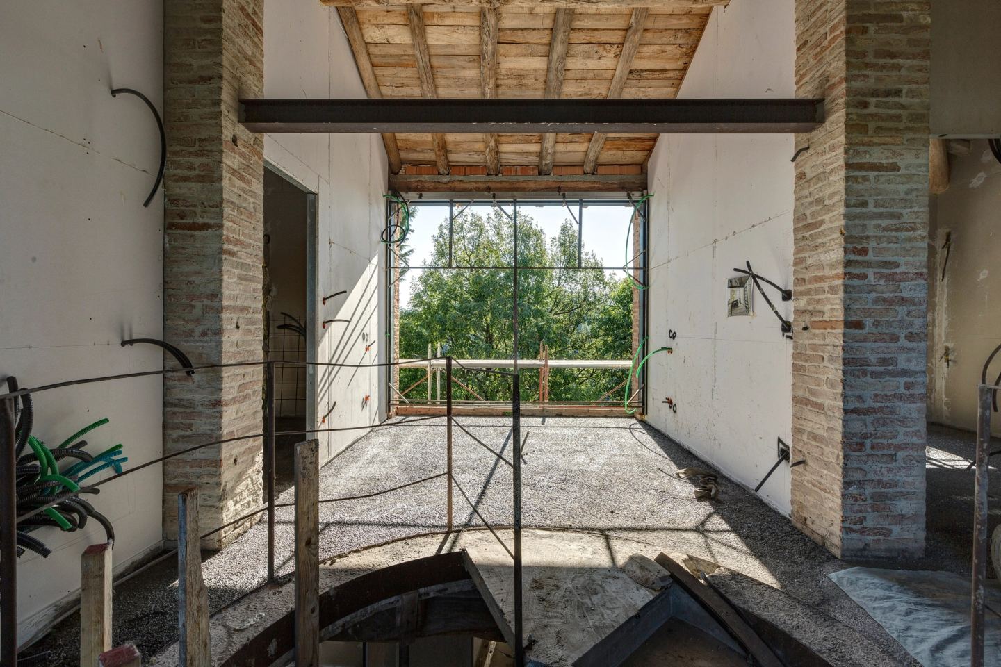 Between the brick piers upstairs, the tall window facing the trees