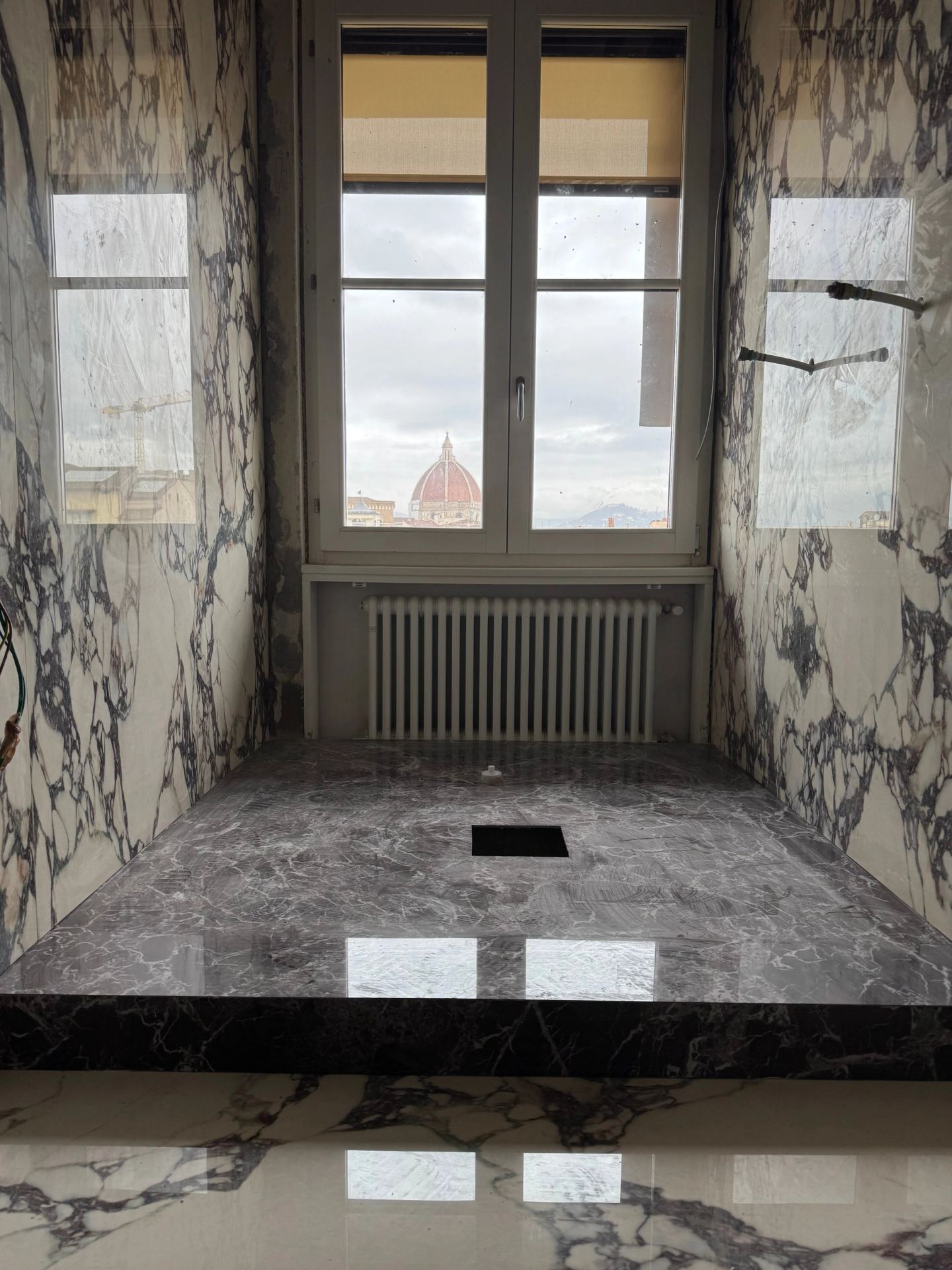 The bathroom with the Duomo view: marble up, the bath platform waiting