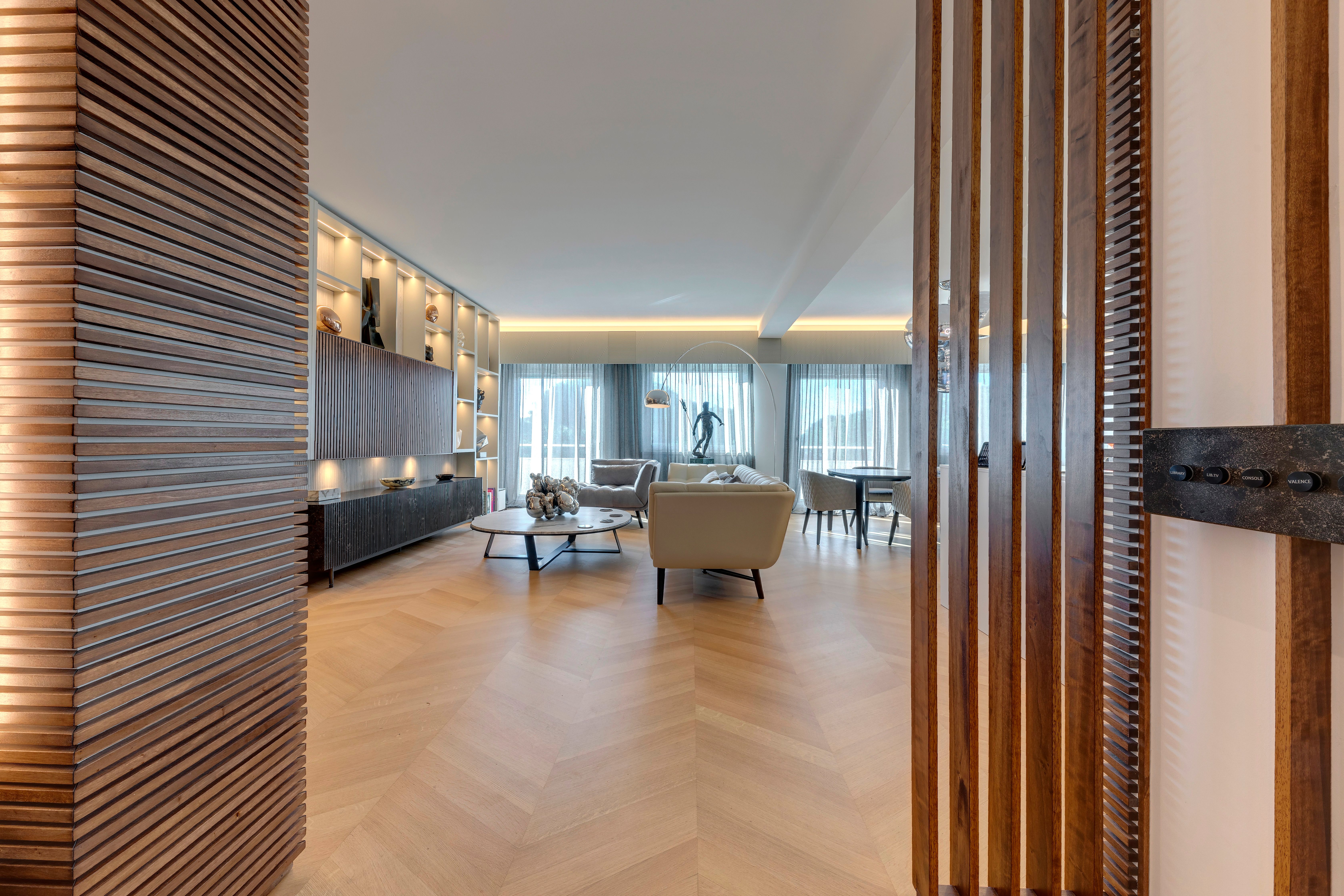 Vertical walnut slats dividing the entrance from the living room