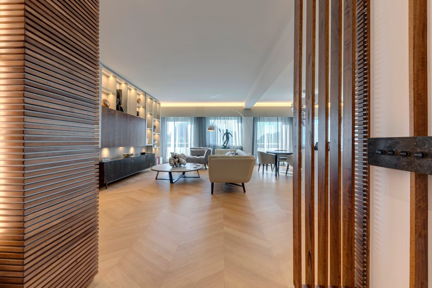Vertical walnut slats dividing the entrance from the living room