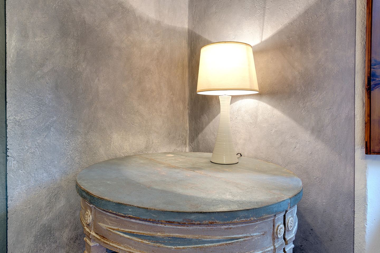A fluted side table under the lamp
