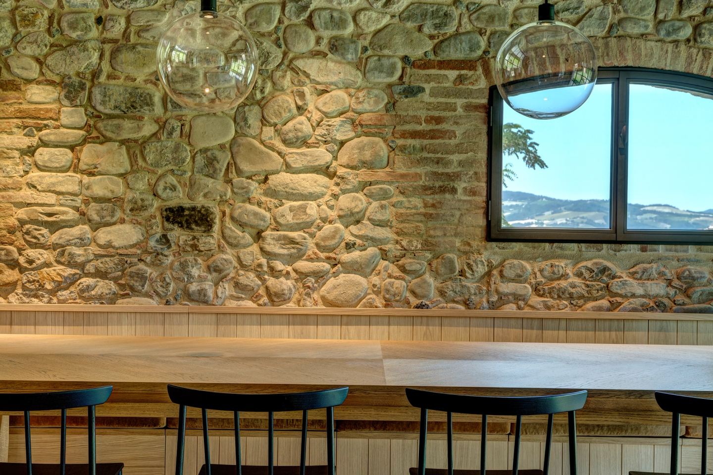 Stools at the counter, river stone behind