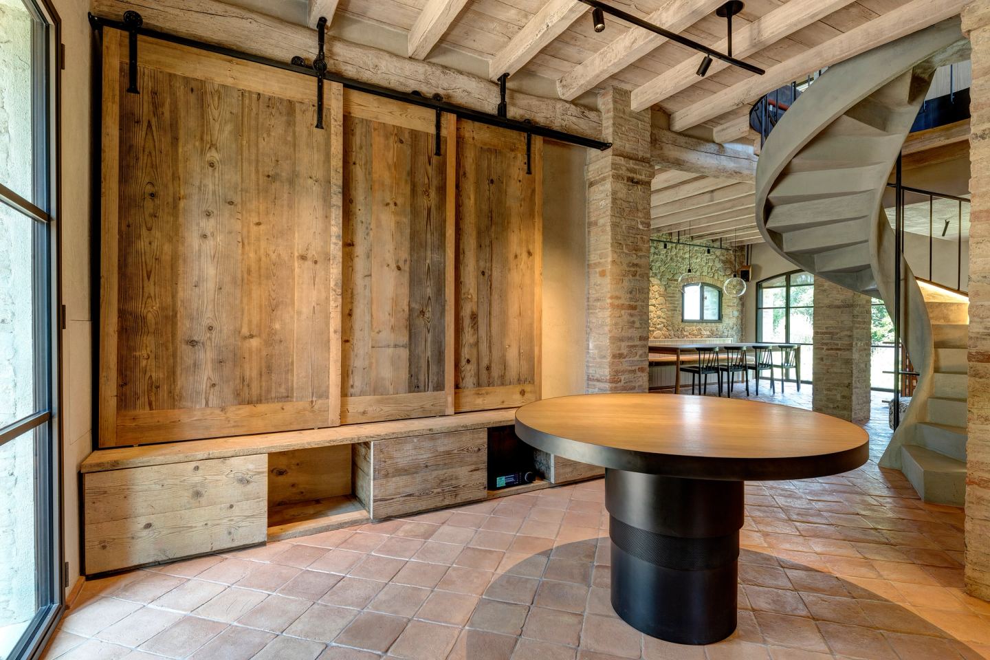 Reclaimed boards slid back, the round table in front