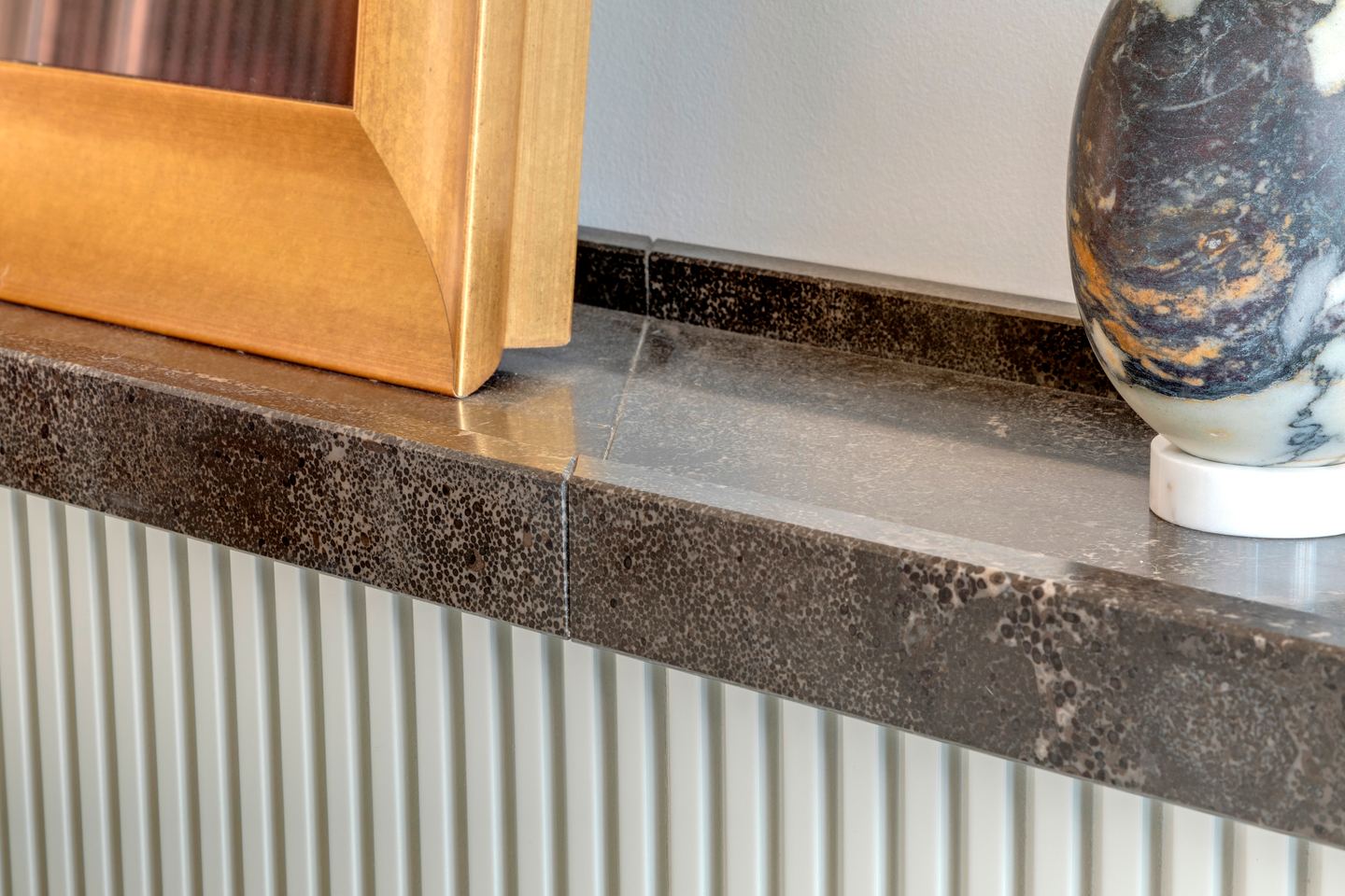 Pietra d'Avola shelf meeting the fluted headboard, close