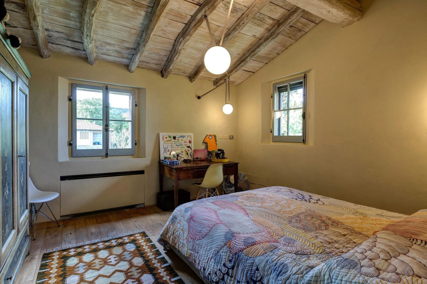 The small bedroom: two globe pendants over the bed, a desk under the window