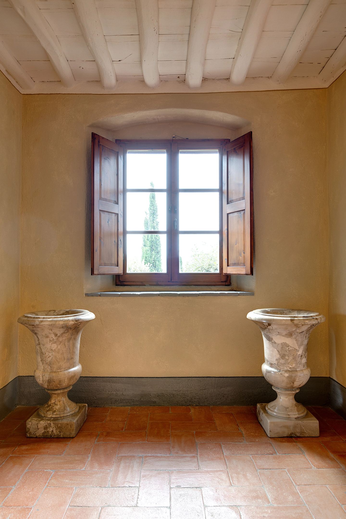 Two stone urns kept under the window