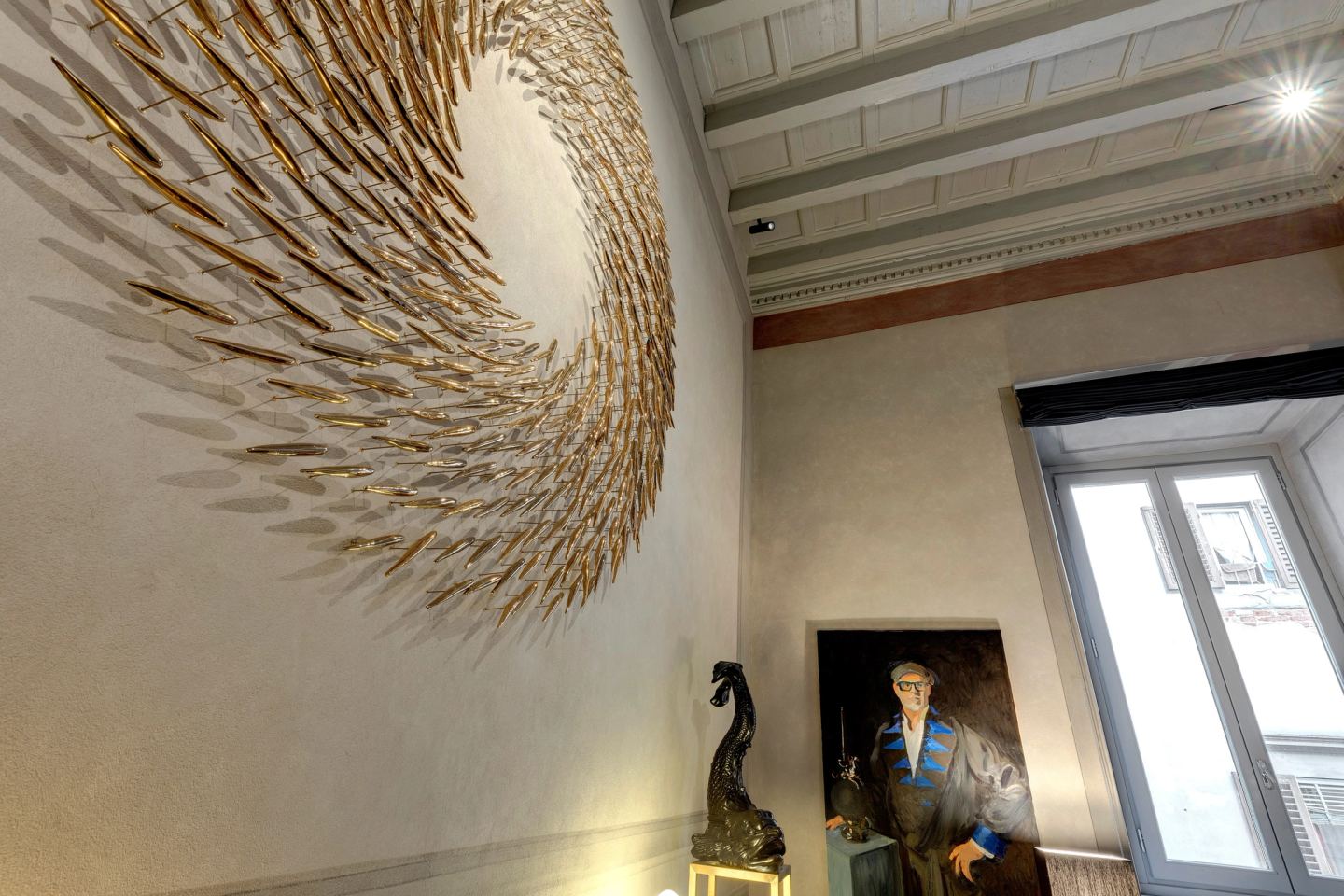 The gold spiral against the pale wall, the painted frieze and the ceiling above