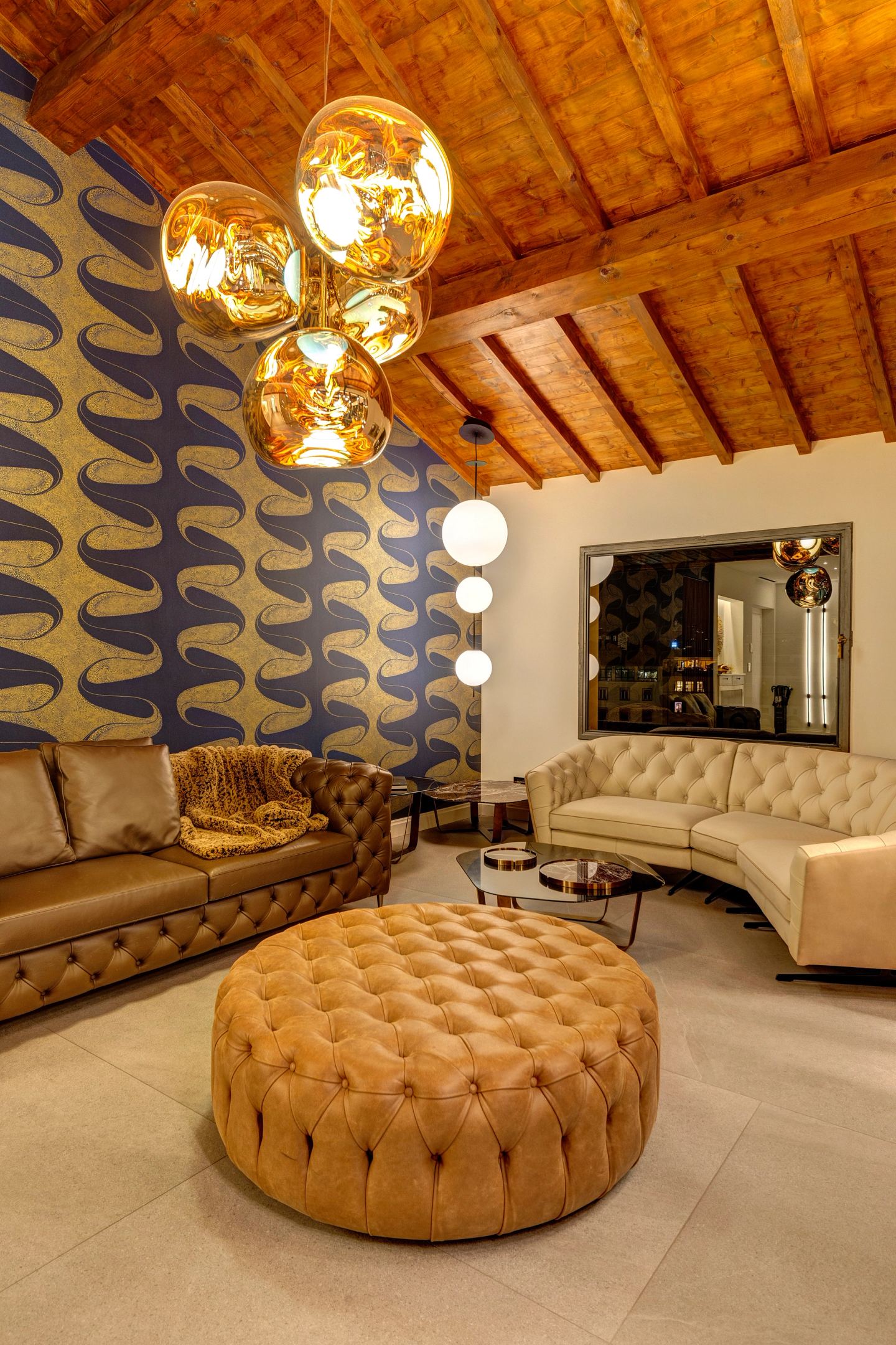 Curved sofa and ottoman at night under the copper globes