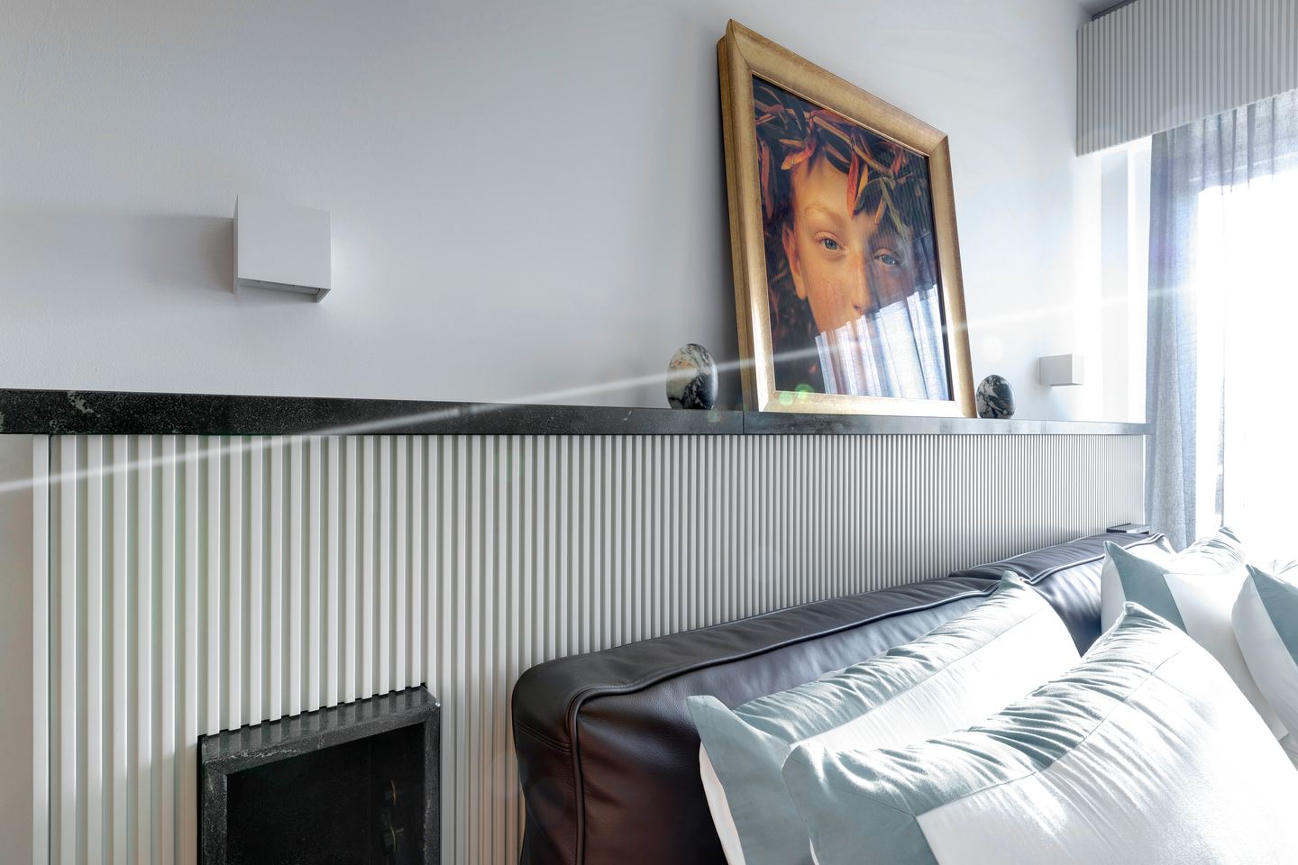The stone shelf behind the bed, the painting resting on it