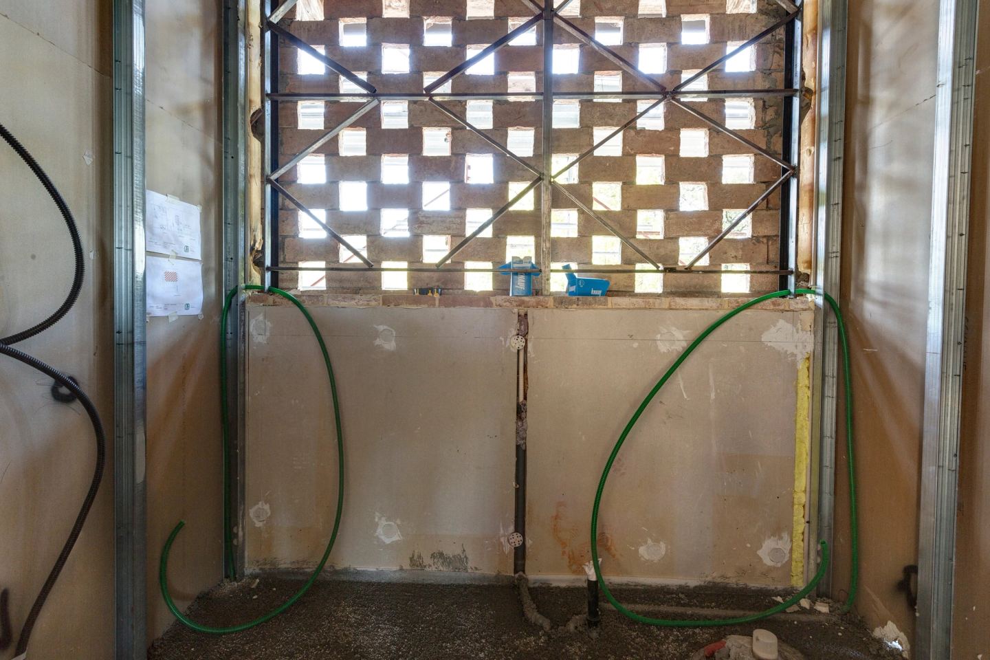 The perforated brick screen, pipes waiting in the wall below