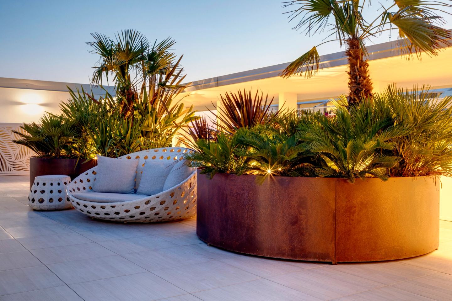 Daybed tondo tra le palme, di sera