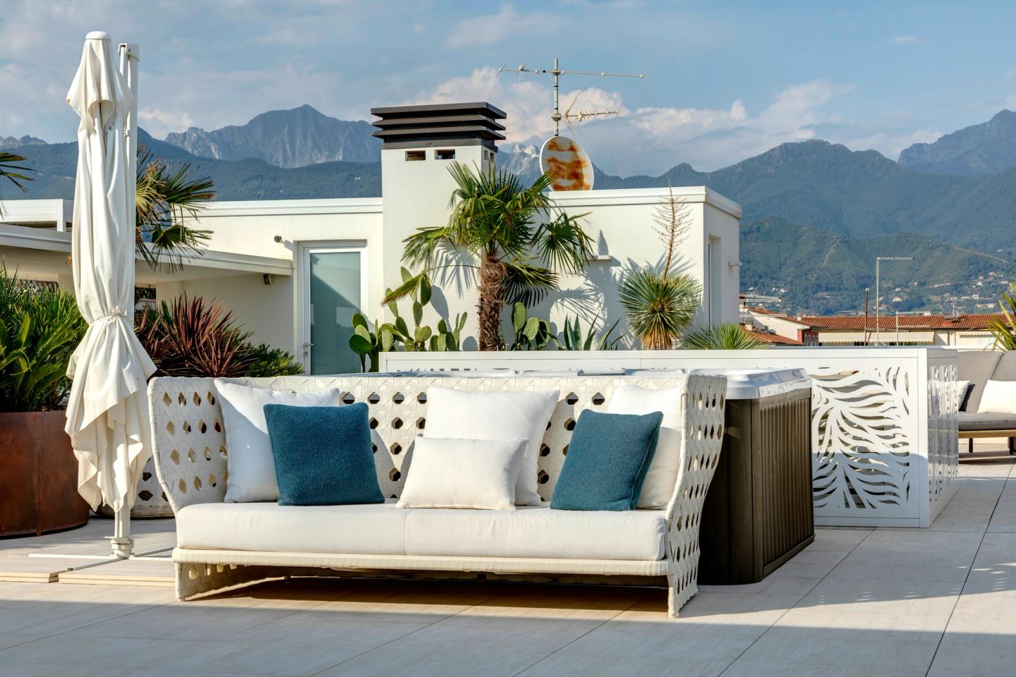 Daybed e cuscini sotto l'ombrellone, le montagne oltre