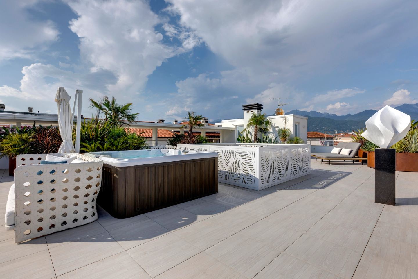 La spa con la copertura, i frangisole e la scultura bianca oltre