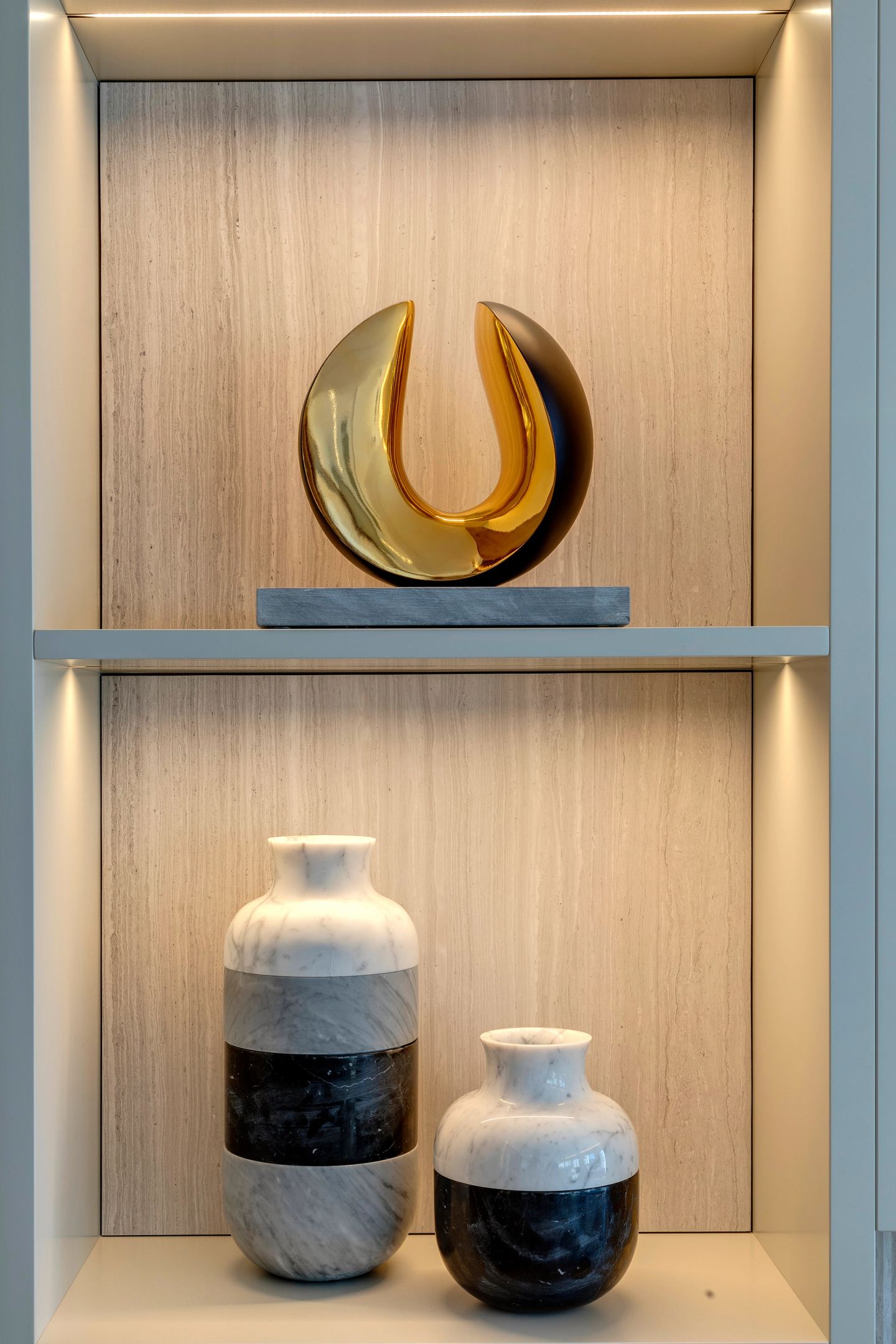 Glass and ceramic objects on a lit shelf