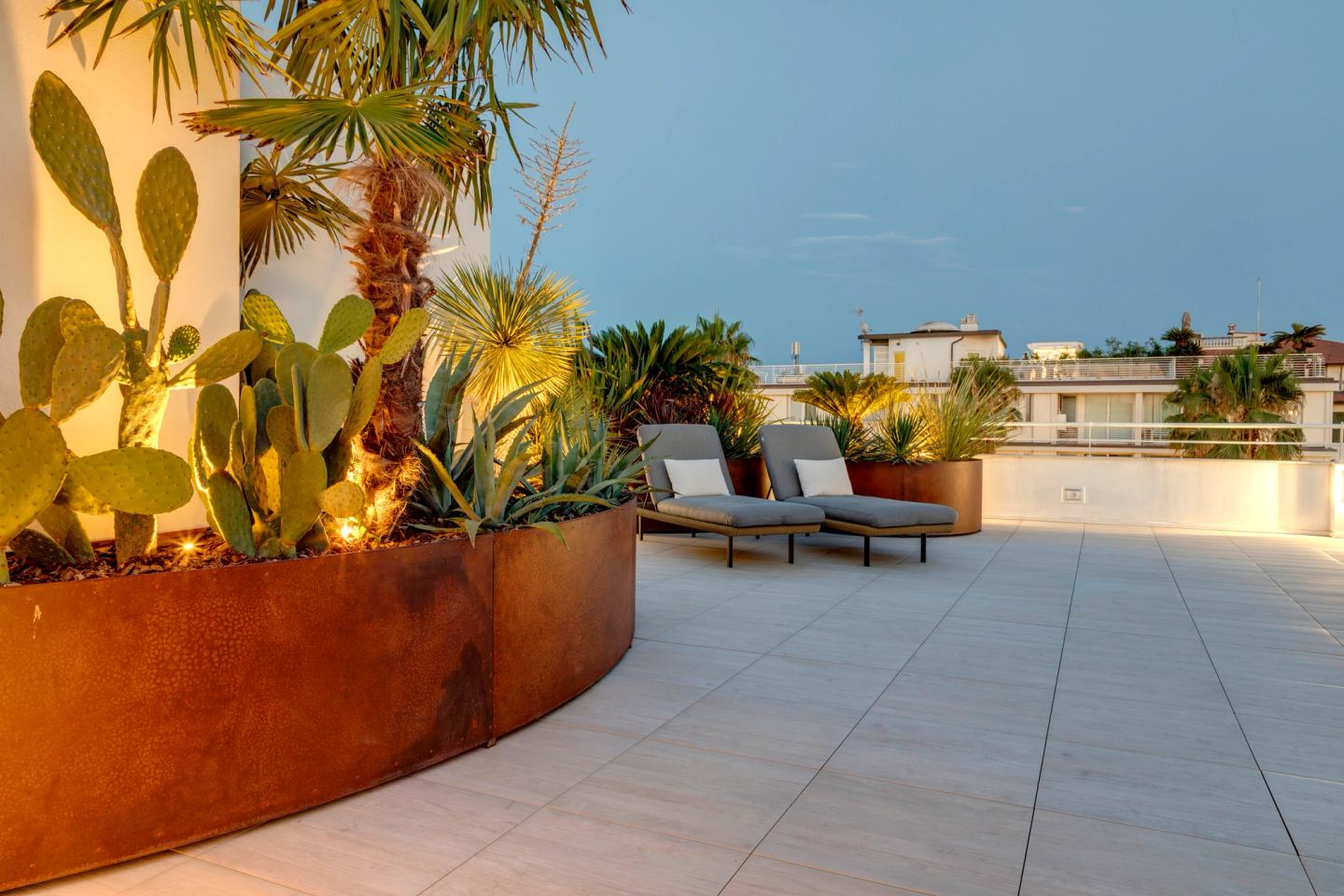 Al tramonto, cactus nel corten accanto ai lettini