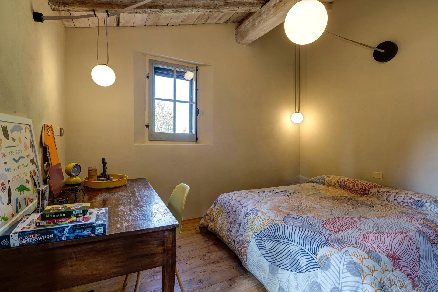 The desk and its pendant, the bed under a floral cover