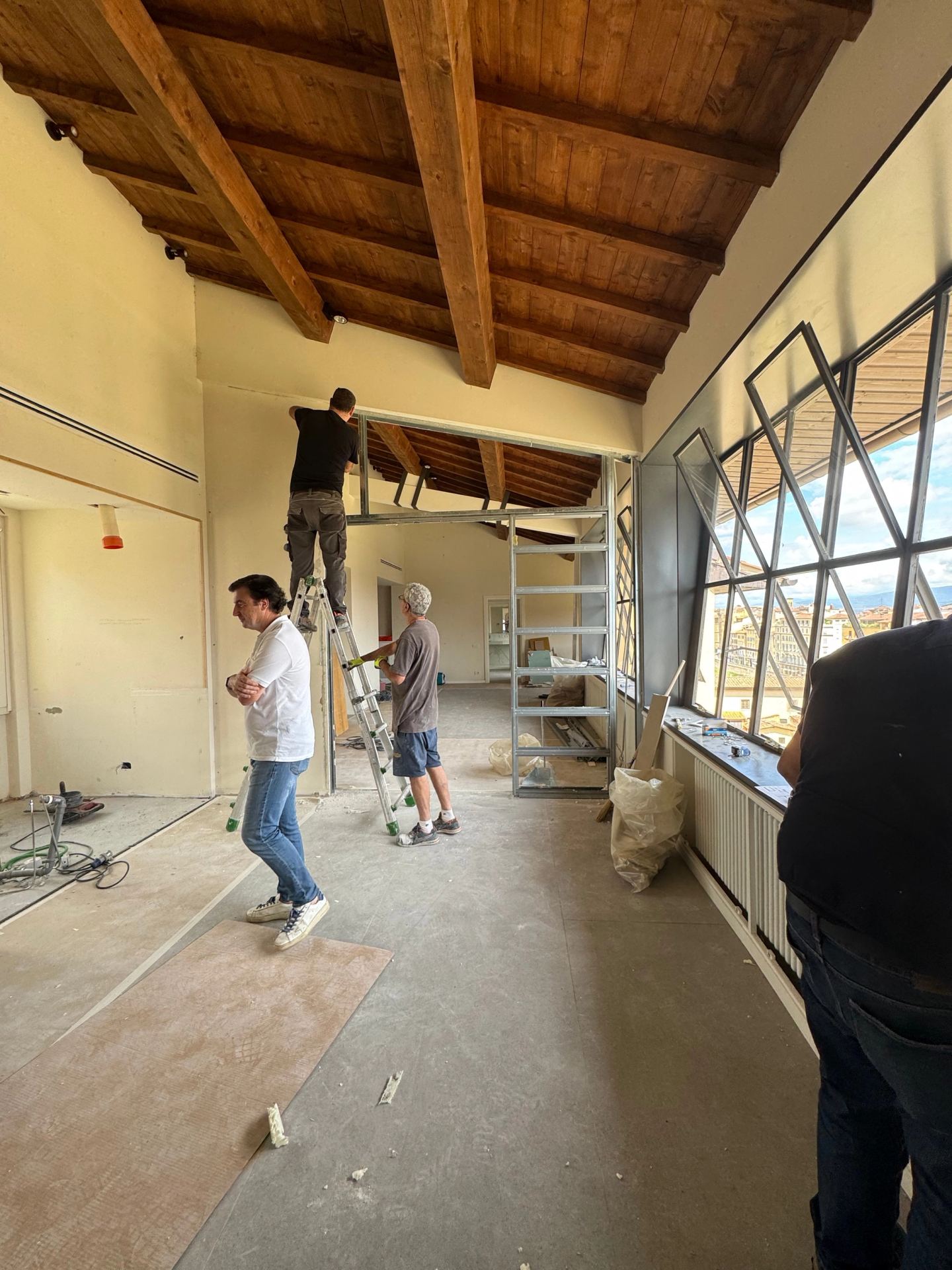 Measuring up in the stripped room under the roof beams