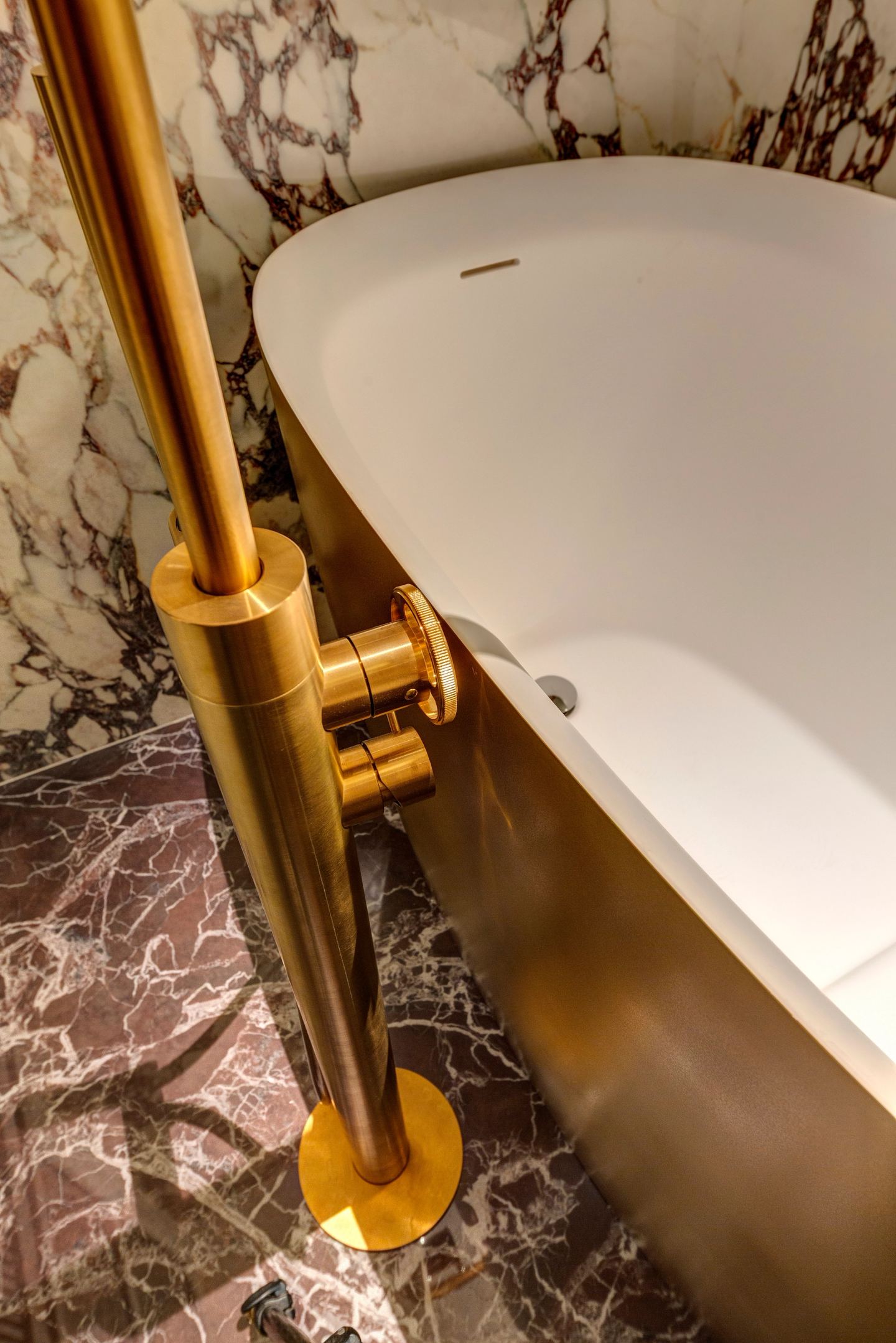 Brass tap and the curve of the bath, close