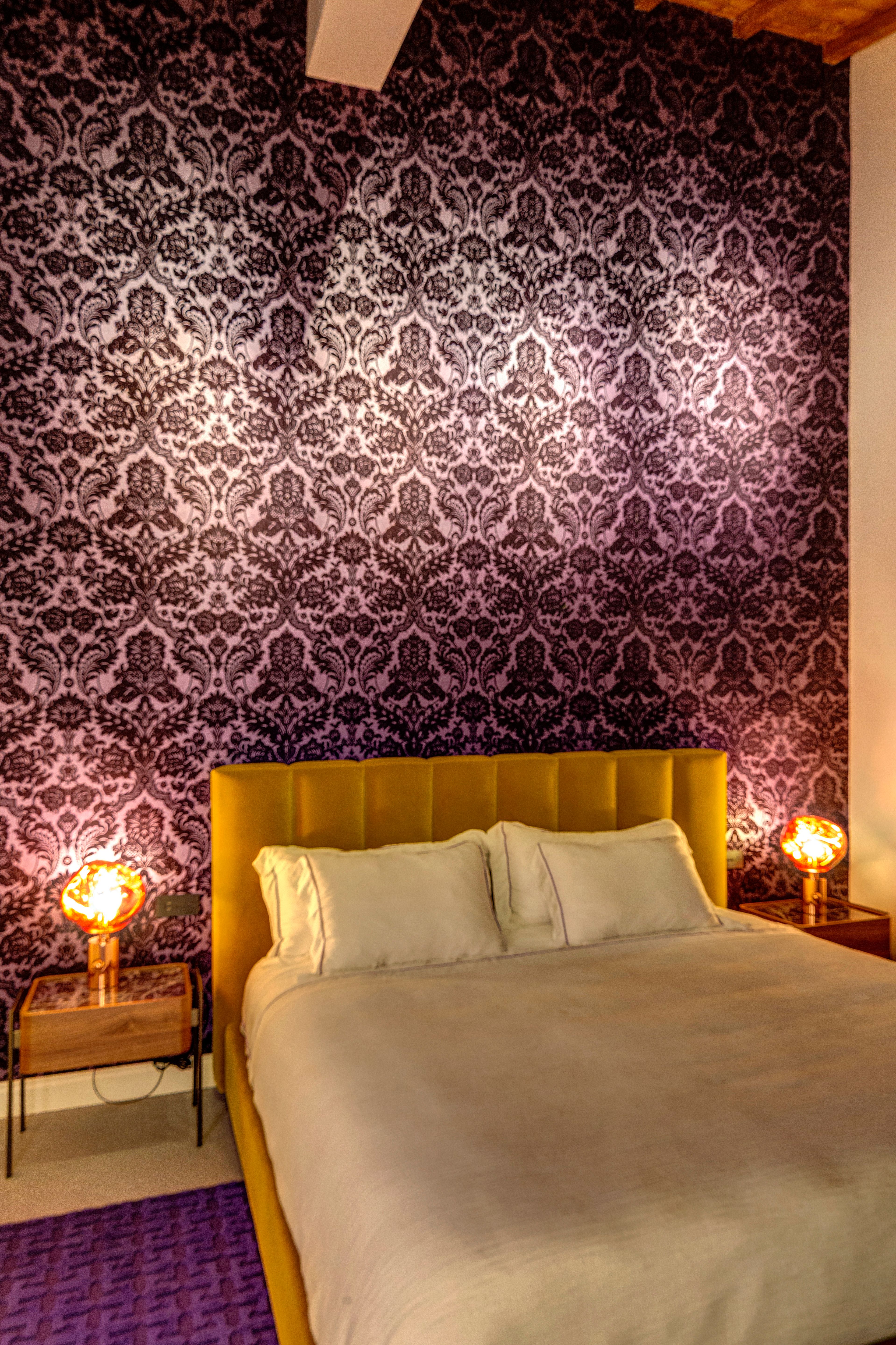 The bedroom after dark, the bedside lamps alight
