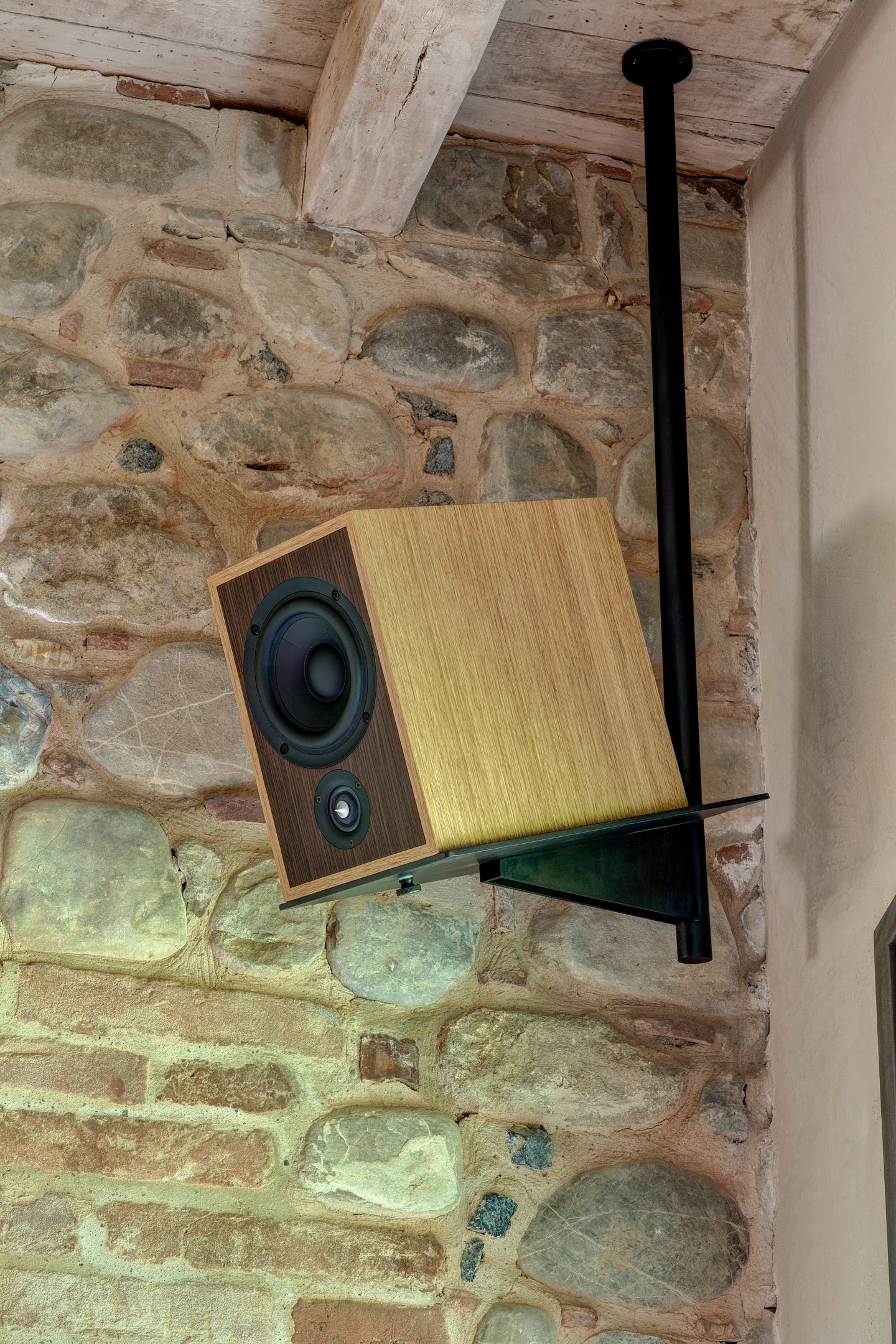 A speaker on its bracket against the stone