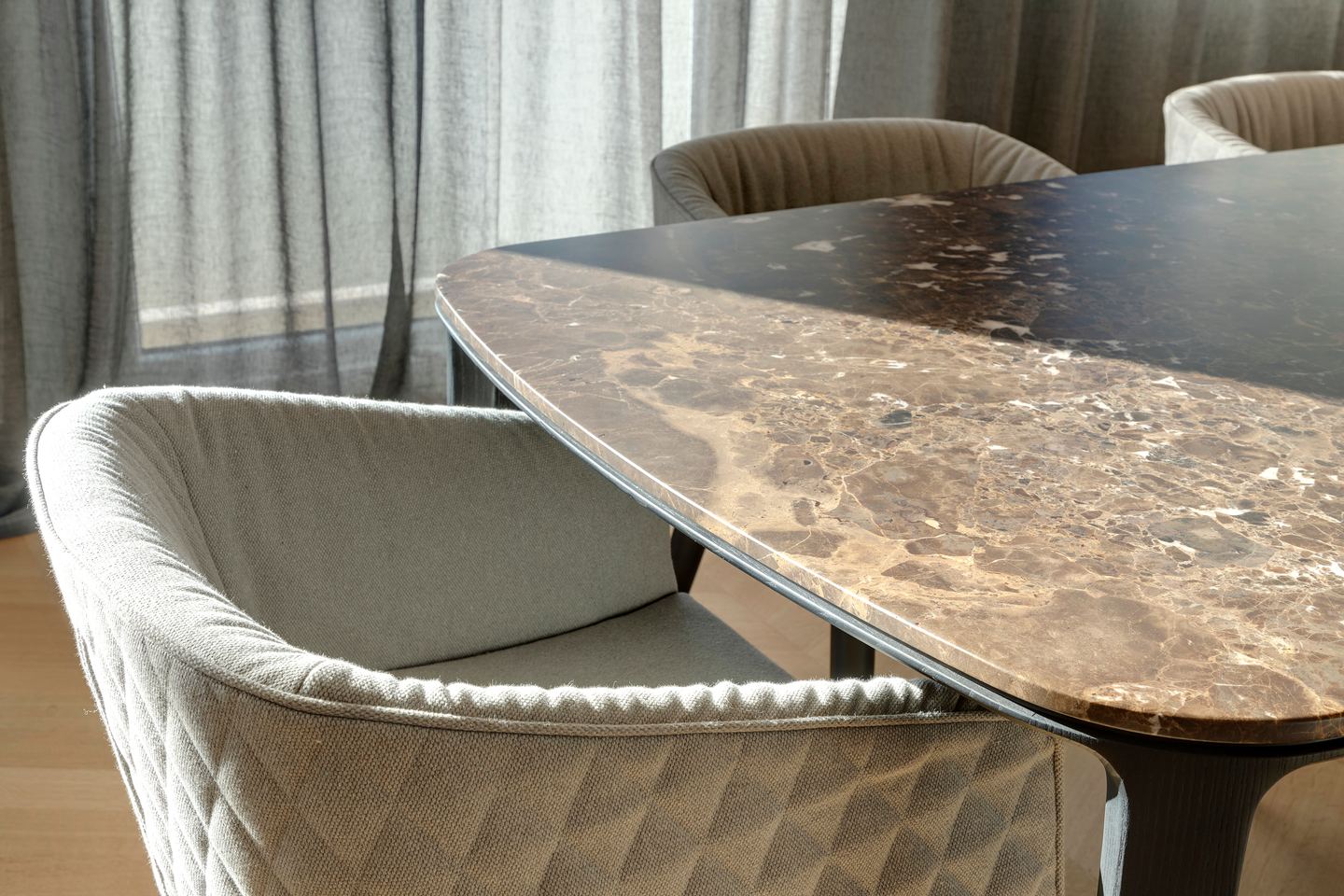 Figured marble table top and quilted chair backs, close