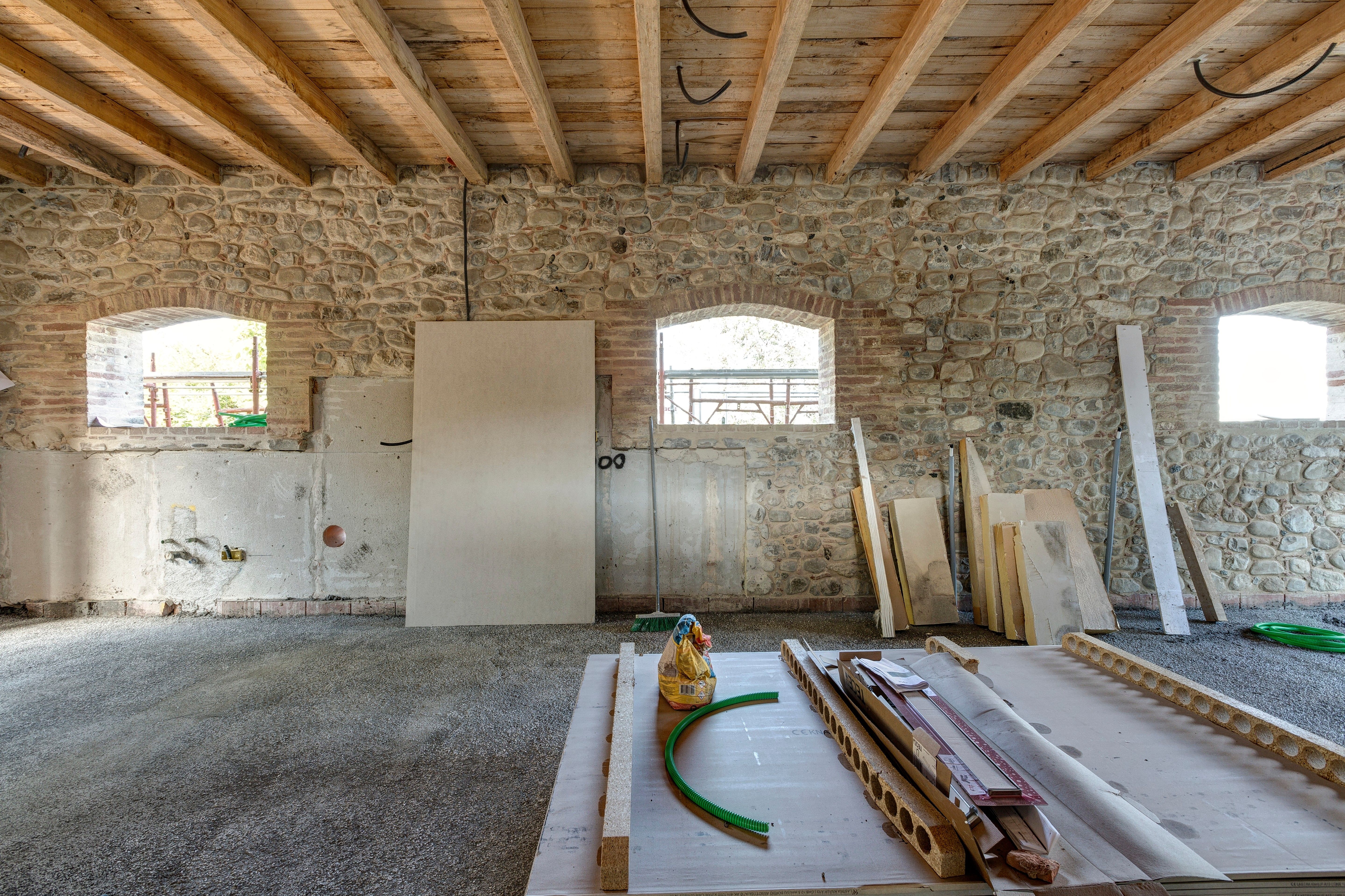 The stone wall and its two arched windows, before the table