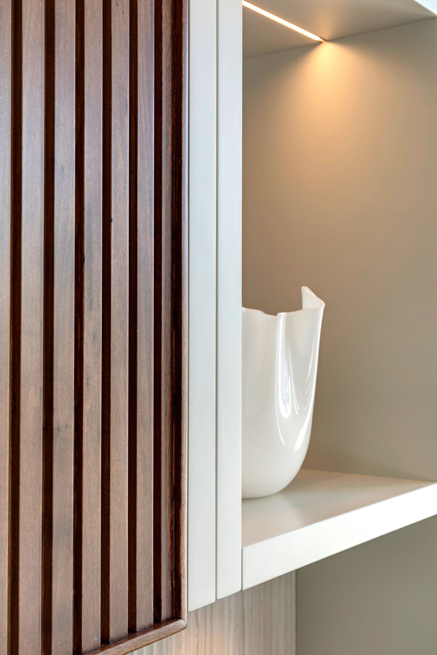 Slatted panel against a white return, shelf beyond