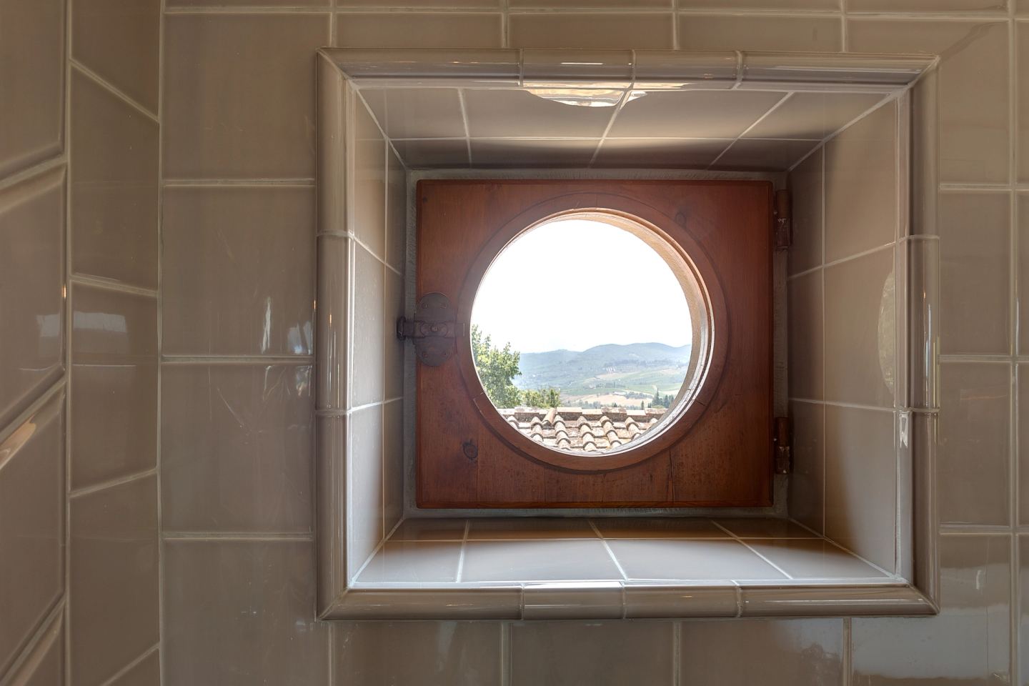 A round window cut through the tiled wall
